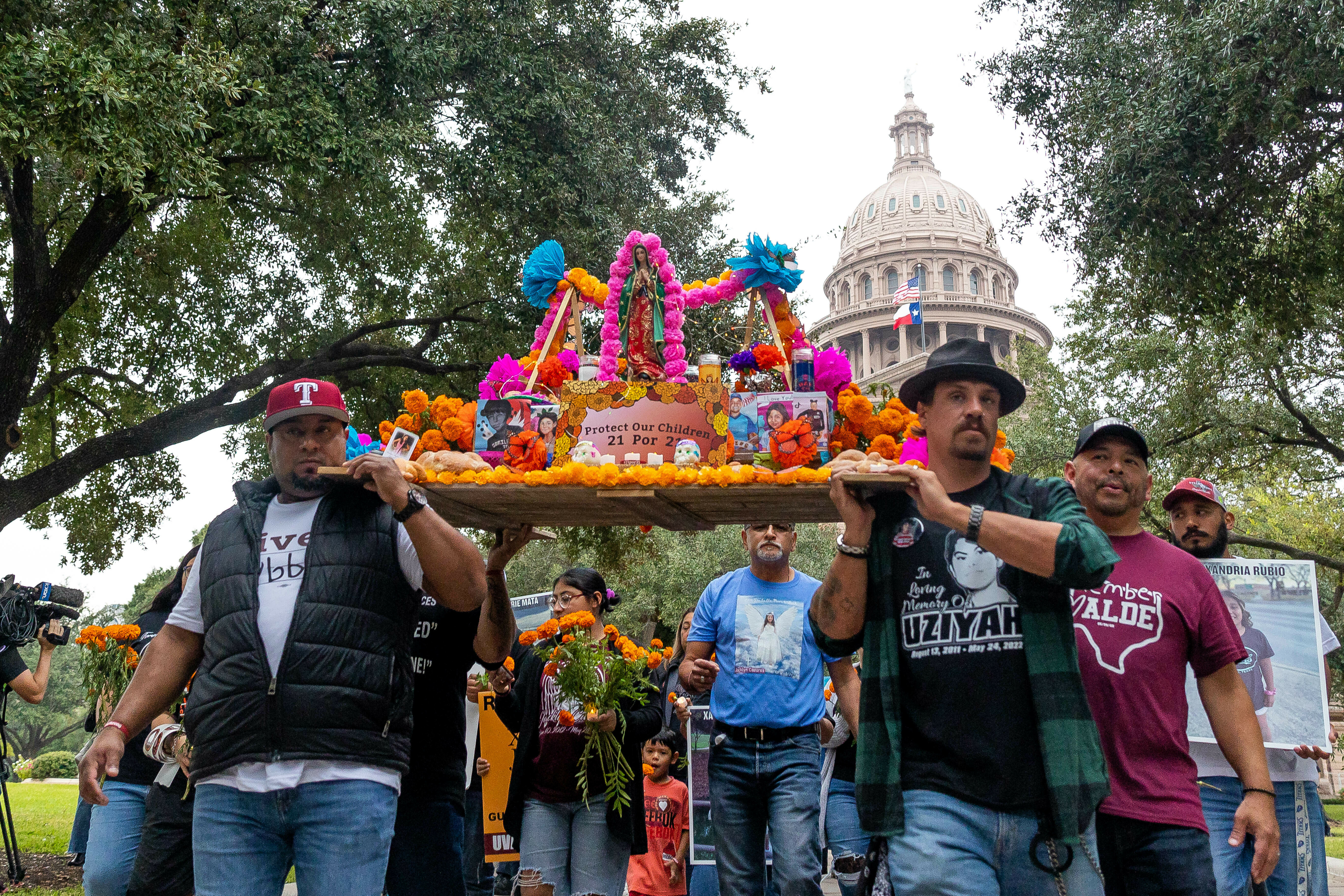 Día de Muertos altar for the 21 victims from the Robb Elementary School shooting being carried by the victims fathers from the Capitol to the Governor's Mansion, protesting for an age increase to purchase AR-15 and requesting everyone to vote. Full story here.