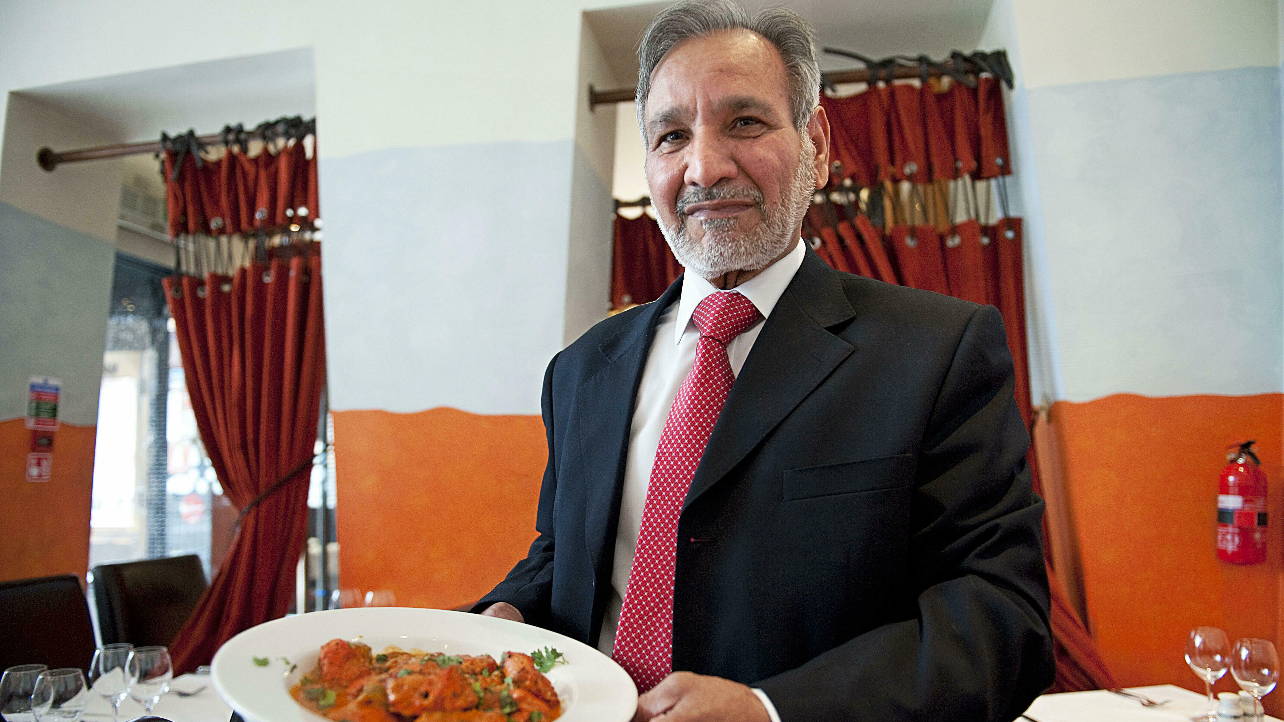 Ahmed Aslam Ali, the owner of the Shish Mahal restaurant in Glasgow, Scotland, is pictured with a plate of chicken tikka masala in his restaurant, on July 29, 2009.