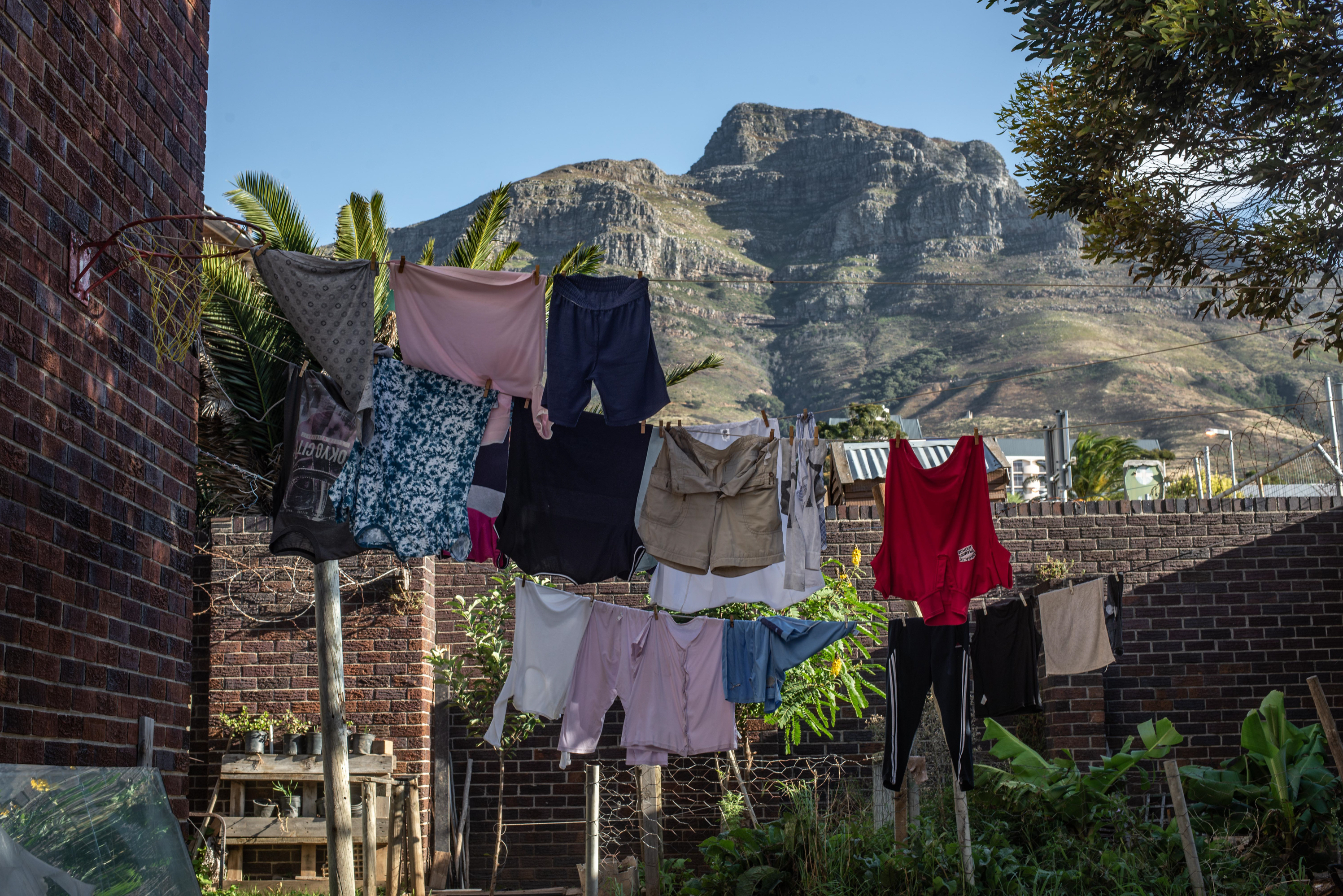 Inside South Africa's 'hijacked' buildings: 'All we want is a place to call home' 14 Laundry hangs on a line against a backdrop of Table Mountain in the back garden of Cissie Gool House.