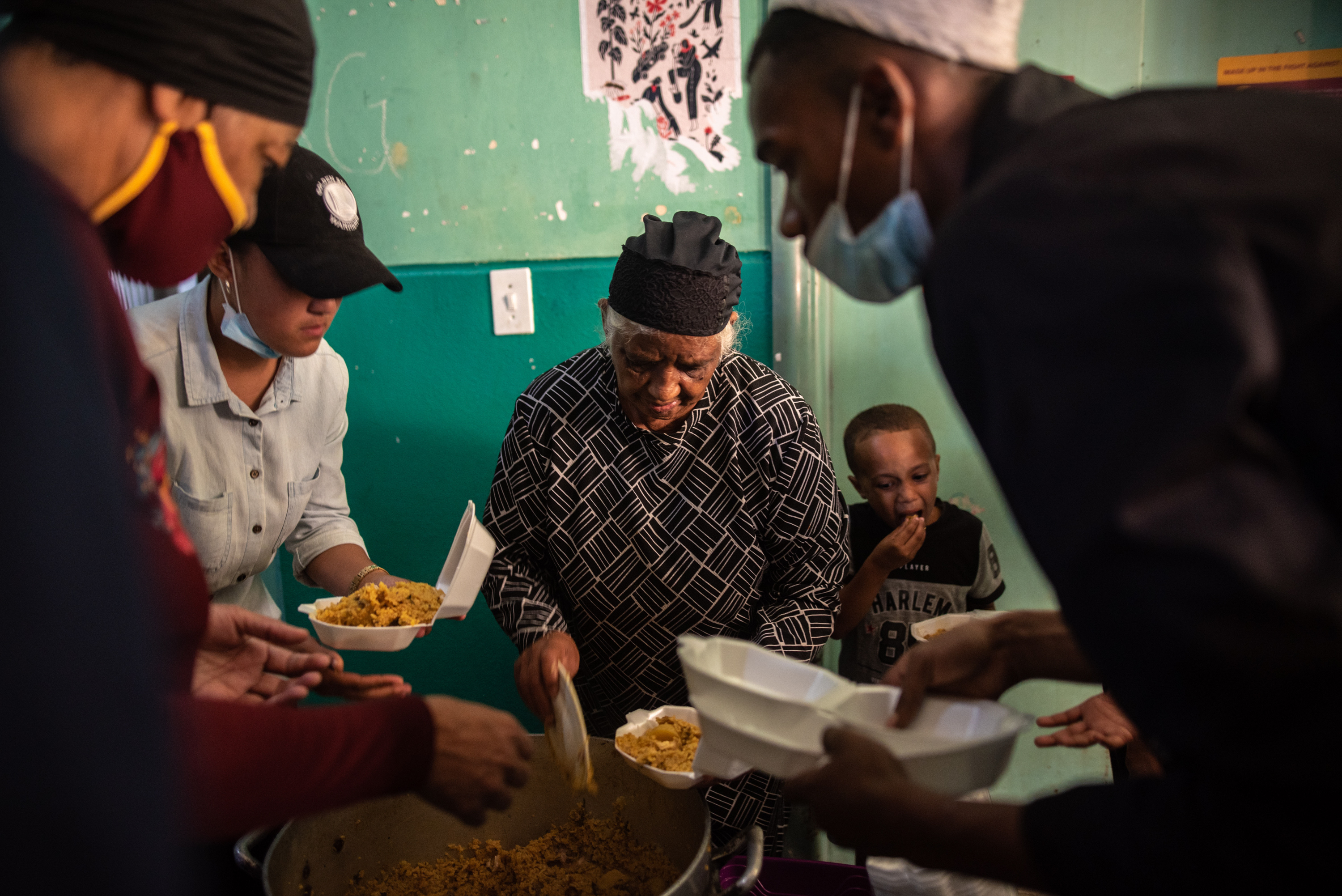 Inside South Africa's 'hijacked' buildings: 'All we want is a place to call home' 5 Auntie Sienna, a long-term resident of Cissie Gool House, distributes food donated to the occupants as a gift for Ramadan.