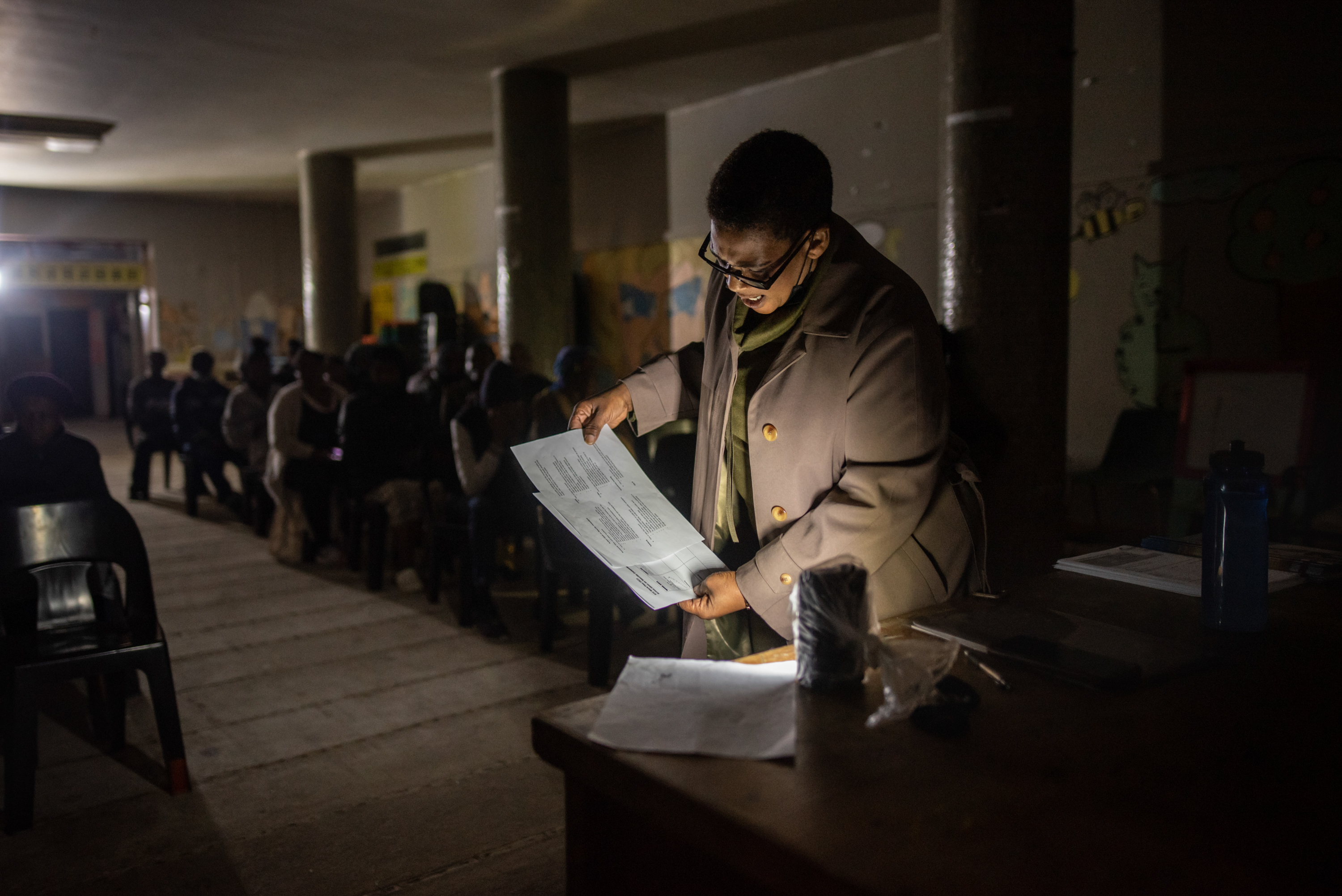 Inside South Africa's 'hijacked' buildings: 'All we want is a place to call home' 9 Community leader Shiela Madikane uses a battery-powered light to read through the agenda during a meeting at Ahmed Kathrada House, an abandoned nursing home in central Cape Town that has been occupied by a community of several hundred evictees and housing activists for nearly six years. The building's electricity was cut off by the city soon after the occupation.