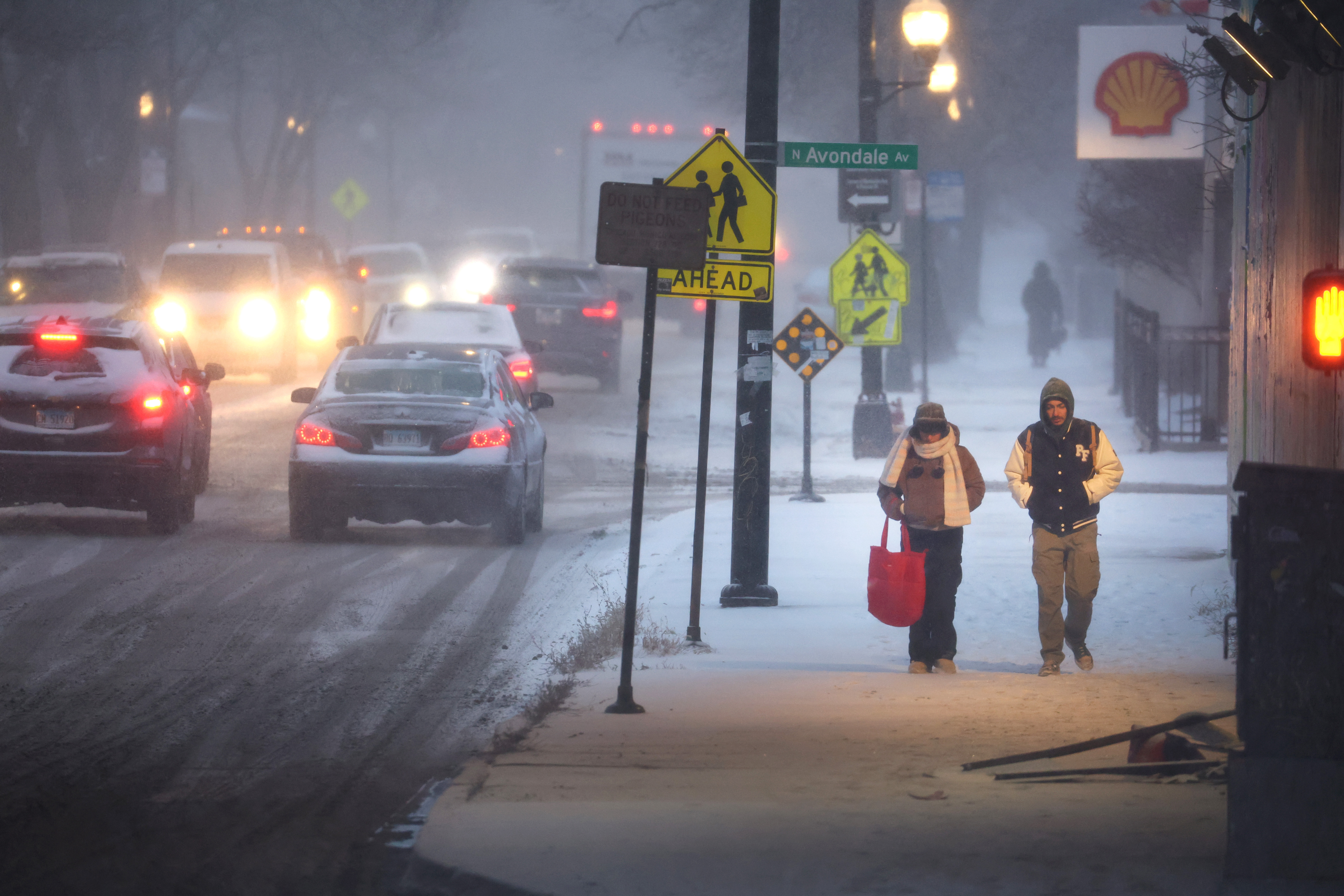 Pedestrians navigate a snow-covered sidewalk in Chicago, on Thursday. Severe winter weather has impacted tens of millions of people in the U.S. (Getty Images)