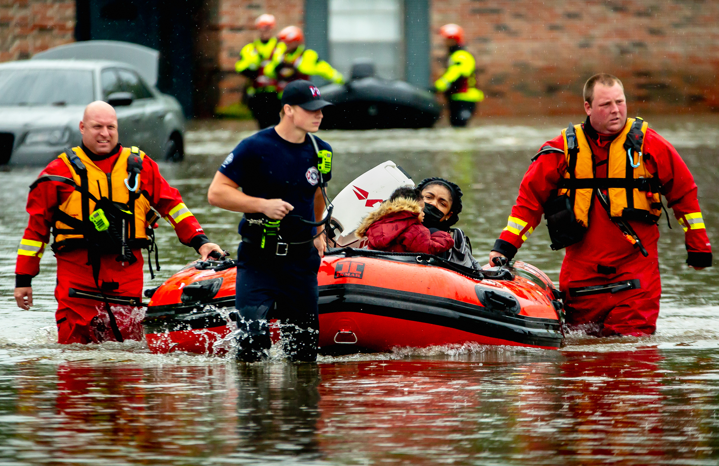 Garry Olson, left, and Sean Boyle, both of the Spanish Lake Fire Department, rescue a resident from extreme flooding engulfing The Reserve at Winding Creek apartment complex on July 26, 2022, in Hazelwood, Mo. Full story here.