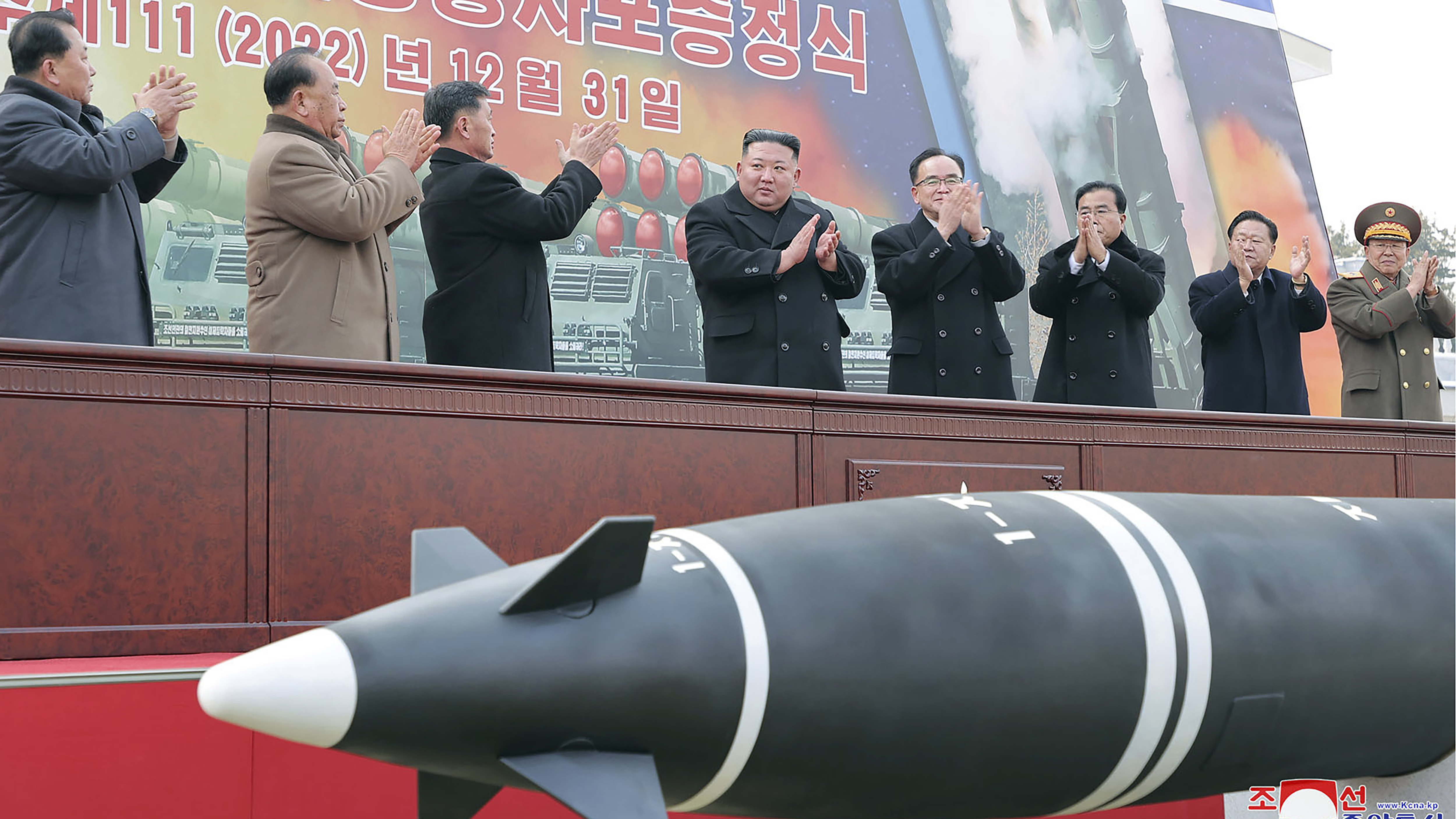 In this photo provided by the North Korean government, North Korean leader Kim Jong Un, center, attends a ceremony of donating 600 mm super-large multiple launch rocket system at a garden of the Workers