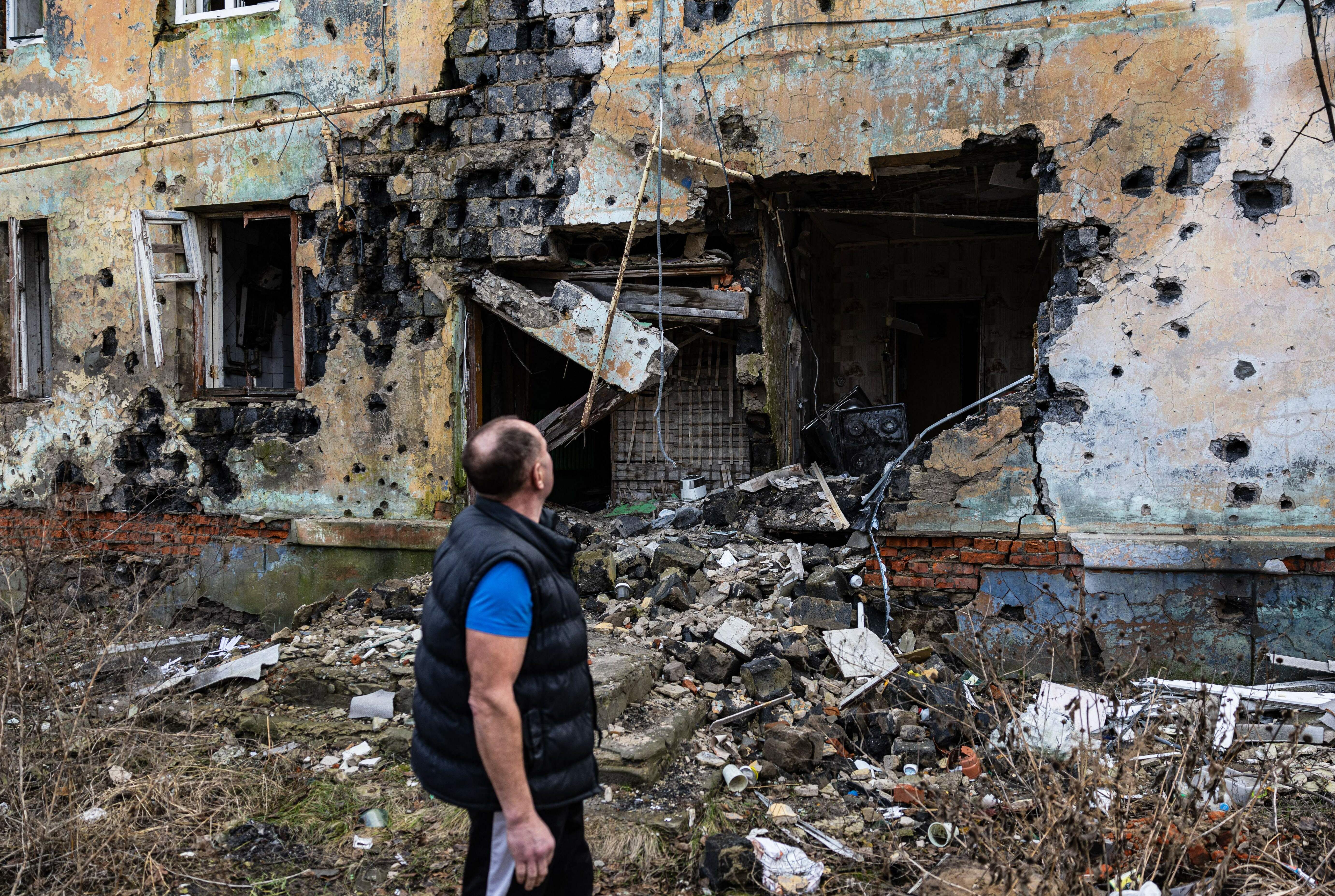 Andryi Pleshan checks destruction around his shelter in the city of Izium in eastern Ukraine on Jan. 2. (AFP via Getty Images)