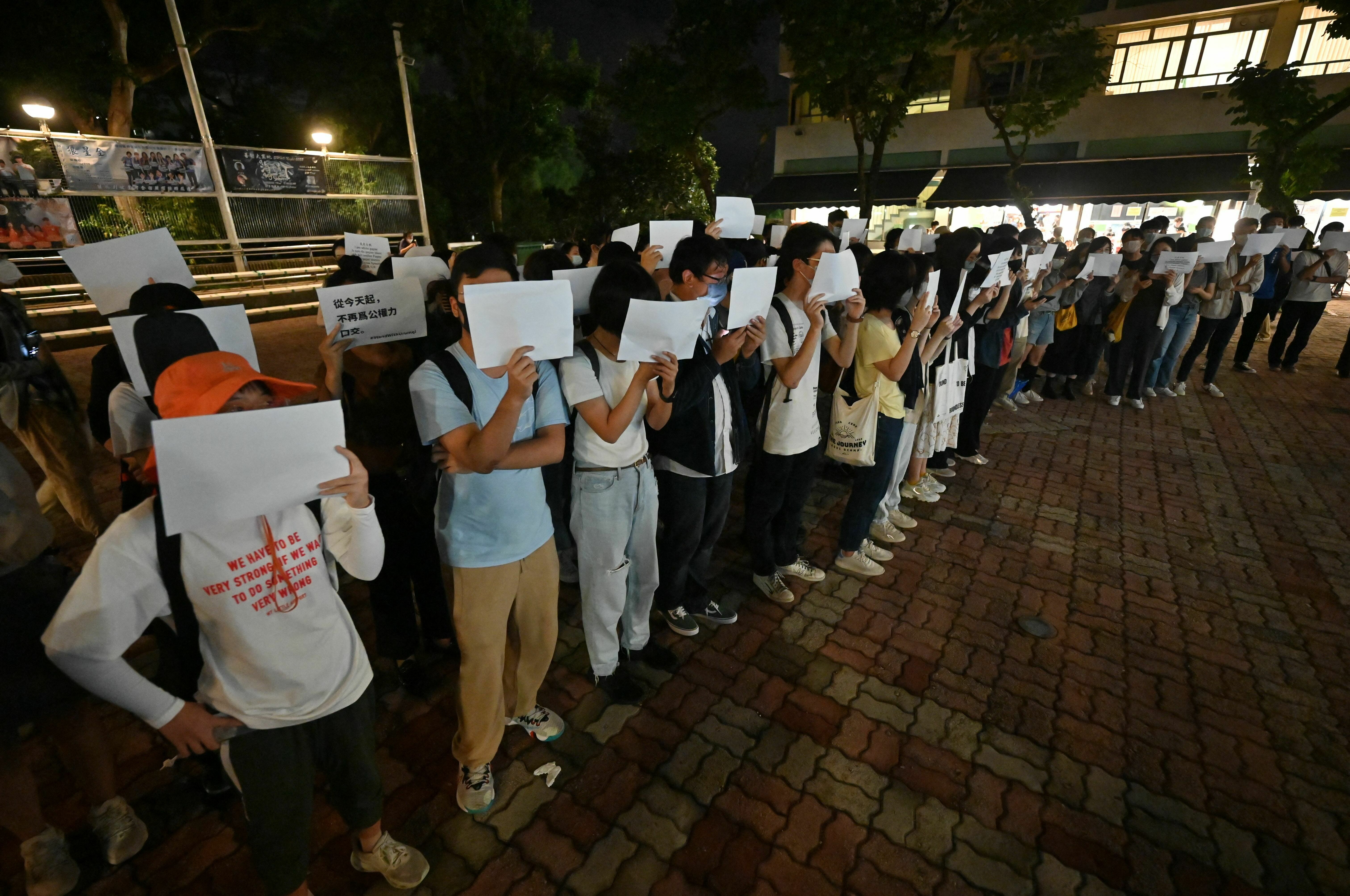 Students hold up placards including blank white sheets of paper on the campus of the Chinese University of Hong Kong, in solidarity with protests held on the mainland over Beijing's COVID-19 restrictions, on Nov. 28. (Peter Parks/AFP via Getty Images)