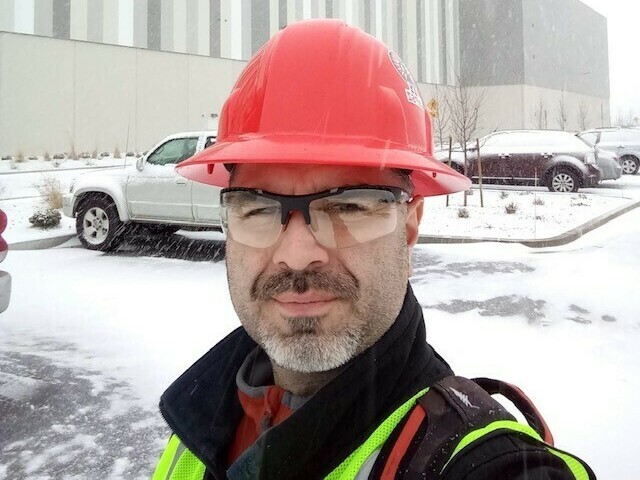 James Lopez stands in front of an Amazon building he helped construct in Washington state. Lopez has suspended a months-long housing search because his family can't afford to keep paying hundreds of dollars in rental application fees. (Courtesy of James Lopez)