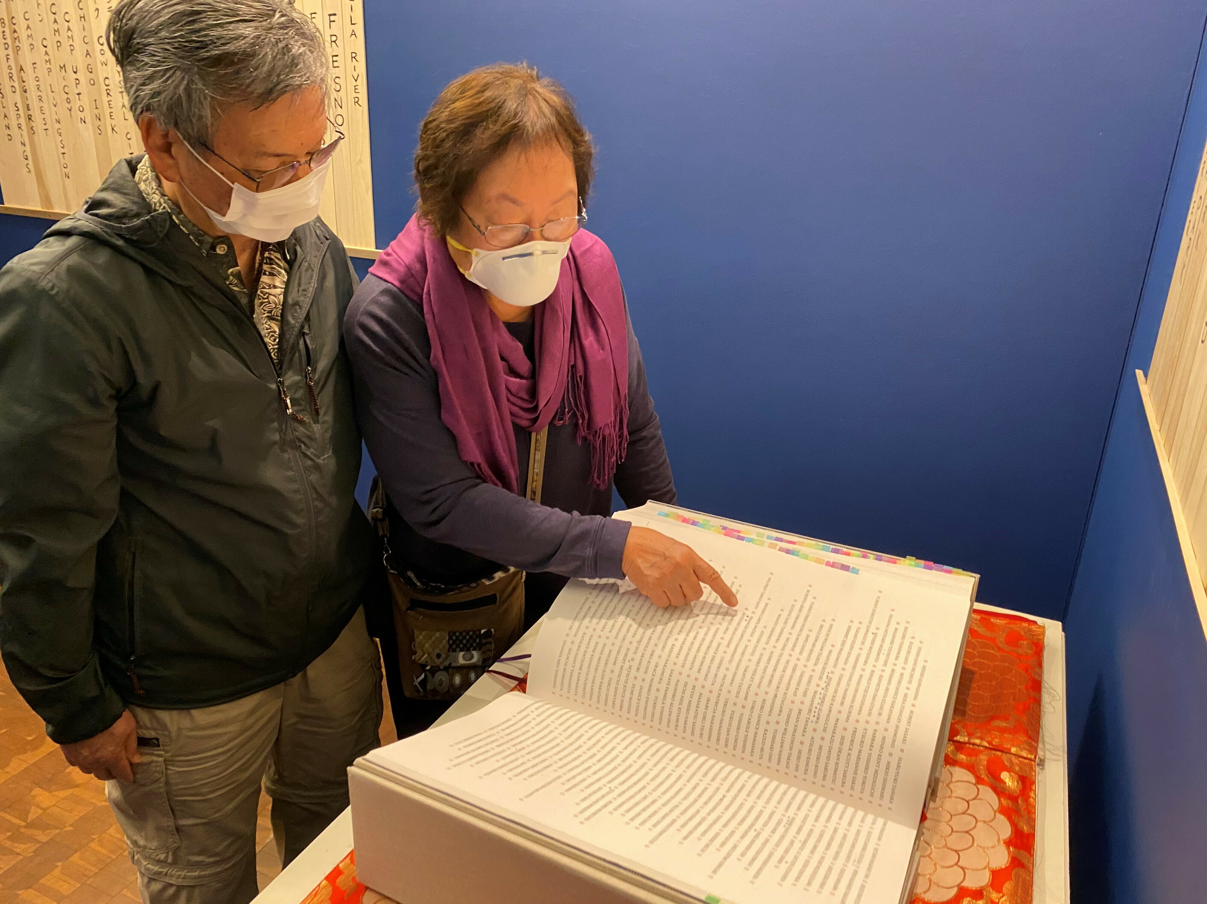 Frances and Ford Kuramoto visiting the Ireichō at the Japanese American National Museum in Los Angeles. The book collects the names of those interned at camps during the war. (NPR)