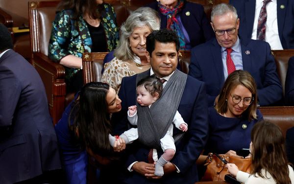 U.S. Rep. Alexandria Ocasio-Cortez, D-N.Y., talks to the infant child of Rep. Jimmy Gomez, D-Calif., inside the House chamber during votes for the next speaker of the House on the first day of the 118th Congress at the U.S. Capitol in Washington, D.C., on Jan. 3.