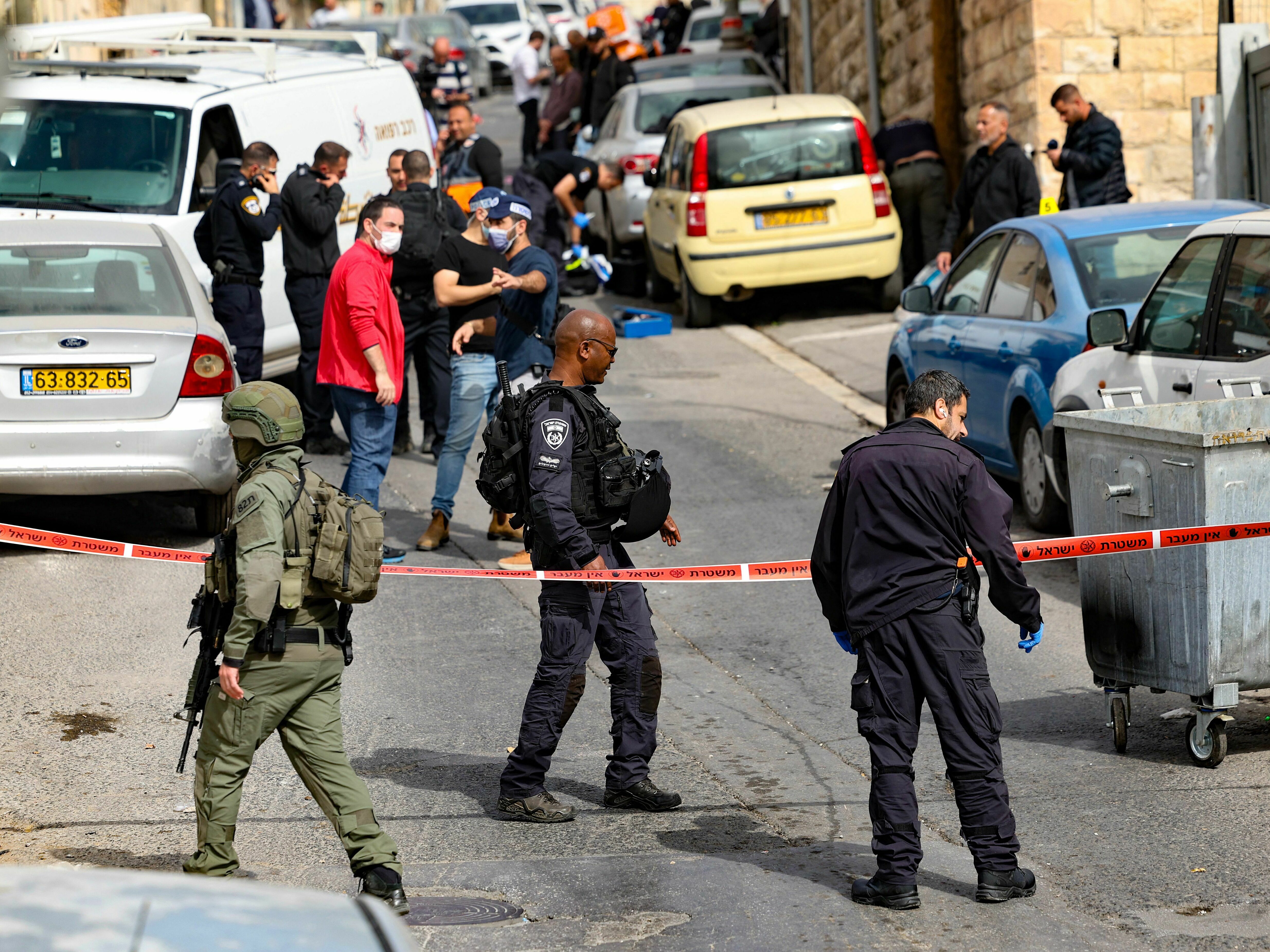 Israeli security forces and emergency service personnel gather at a cordoned-off area in Jerusalem's predominantly Arab neighborhood of Silwan, where police say an assailant shot and wounded two people on Saturday. (AFP via Getty Images)