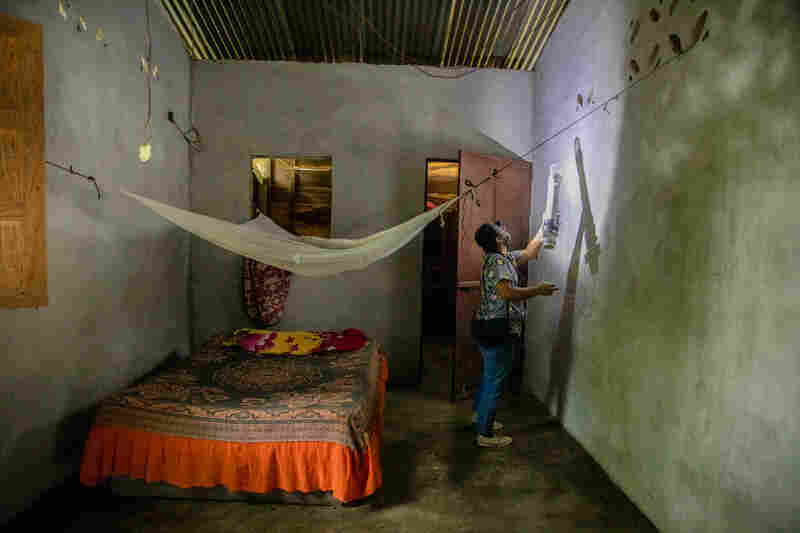 Cecilia González uses the insectazooka to collect mosquito samples at a house in the village of Chiquirines, Guatemala.