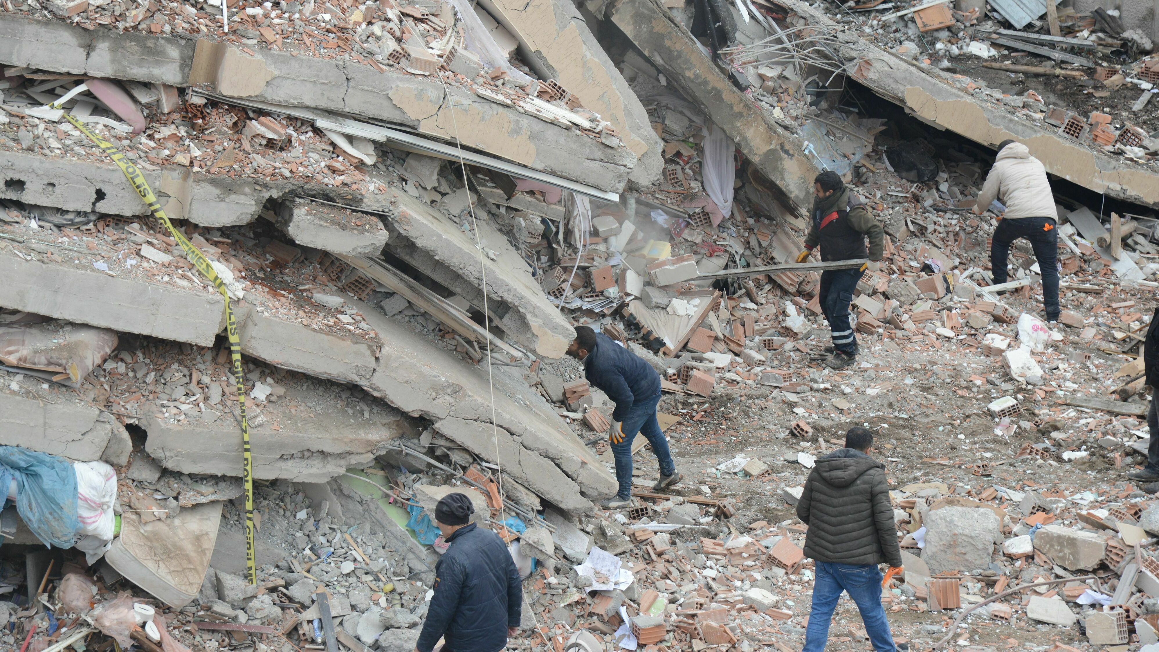 Rescue workers and volunteers conduct search-and-rescue operations in the rubble of a collapsed building, in Diyarbakir, Turkey, after Monday