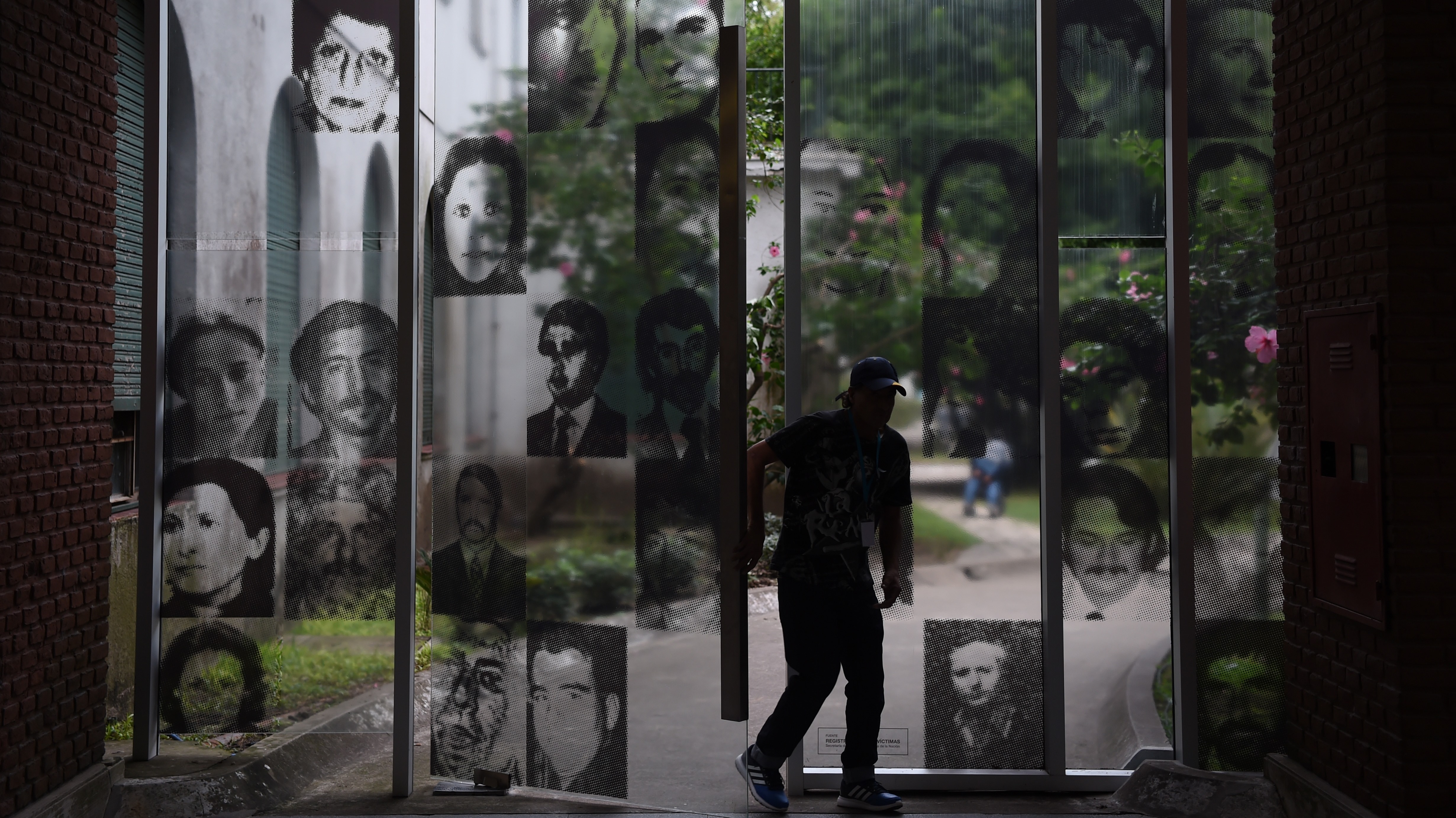 A visitor enters the Officers Casino building at ESMA on March 19, 2016. The windows are filled with images of civilians who were tortured and killed here.