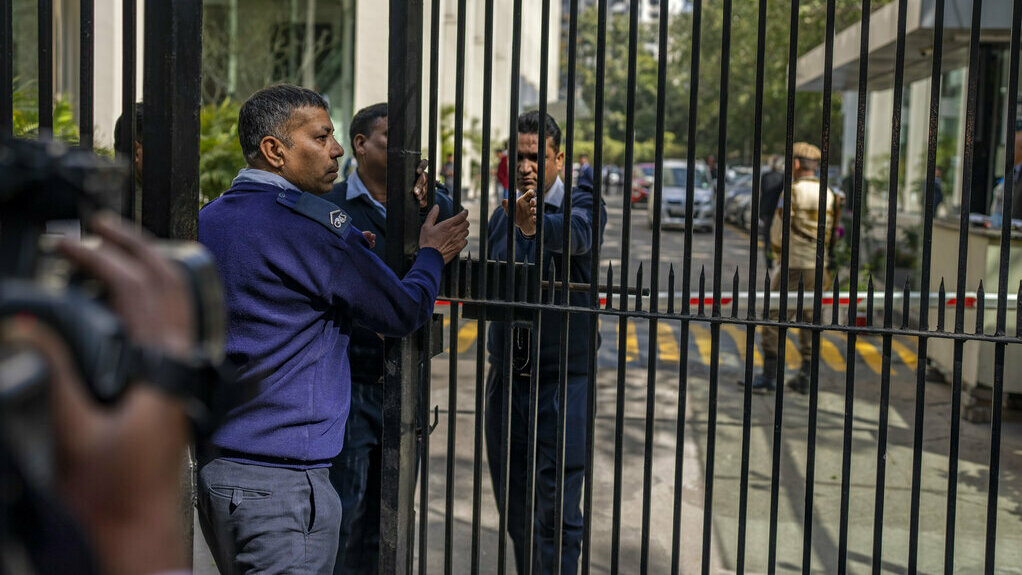 Private security guards close the gate of a building housing BBC office in New Delhi, India.
