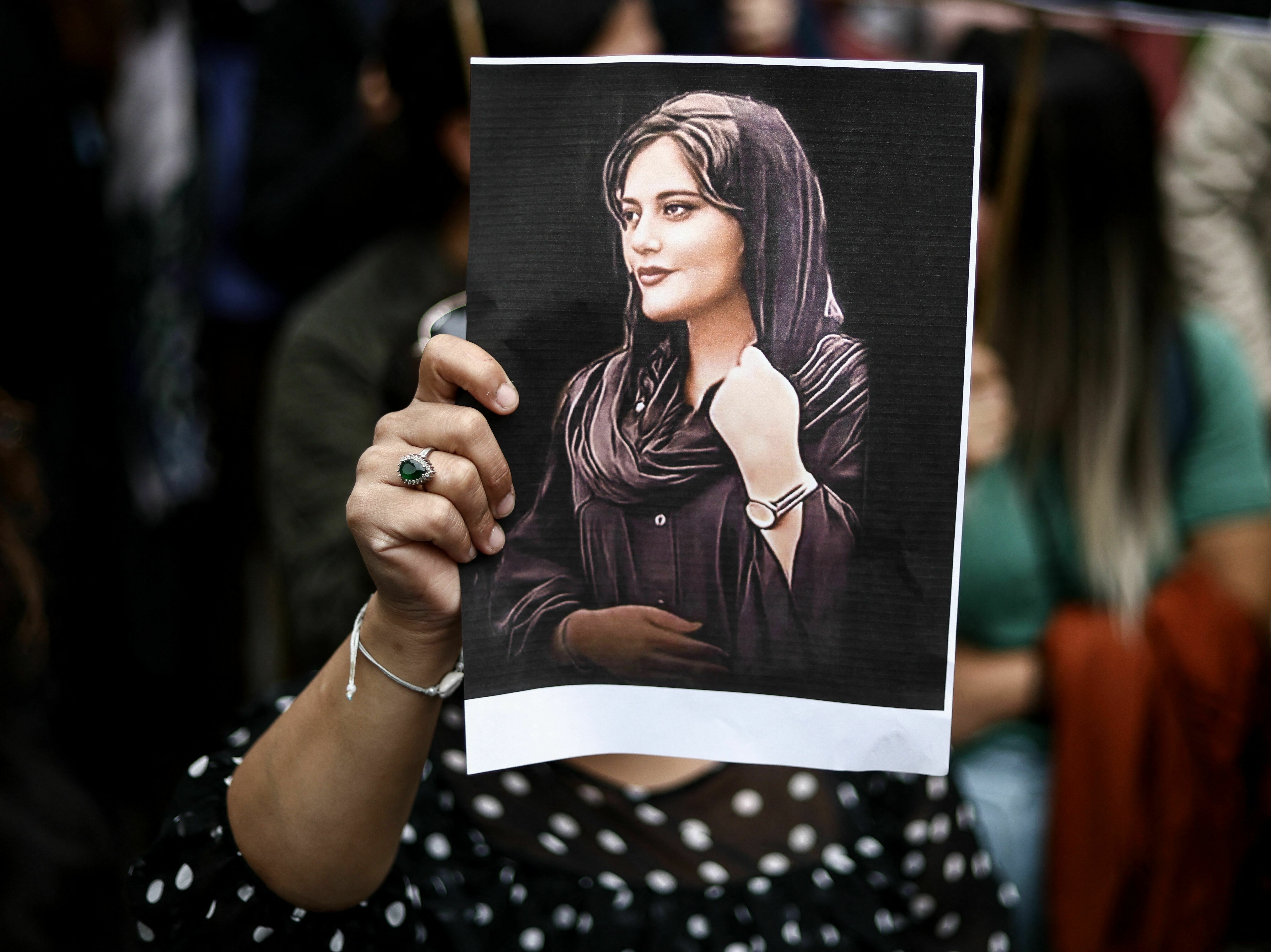 A protester holds a portrait of Mahsa Amini during a demonstration in her support in front of the Iranian embassy in Brussels on September 23, 2022. (AFP via Getty Images)
