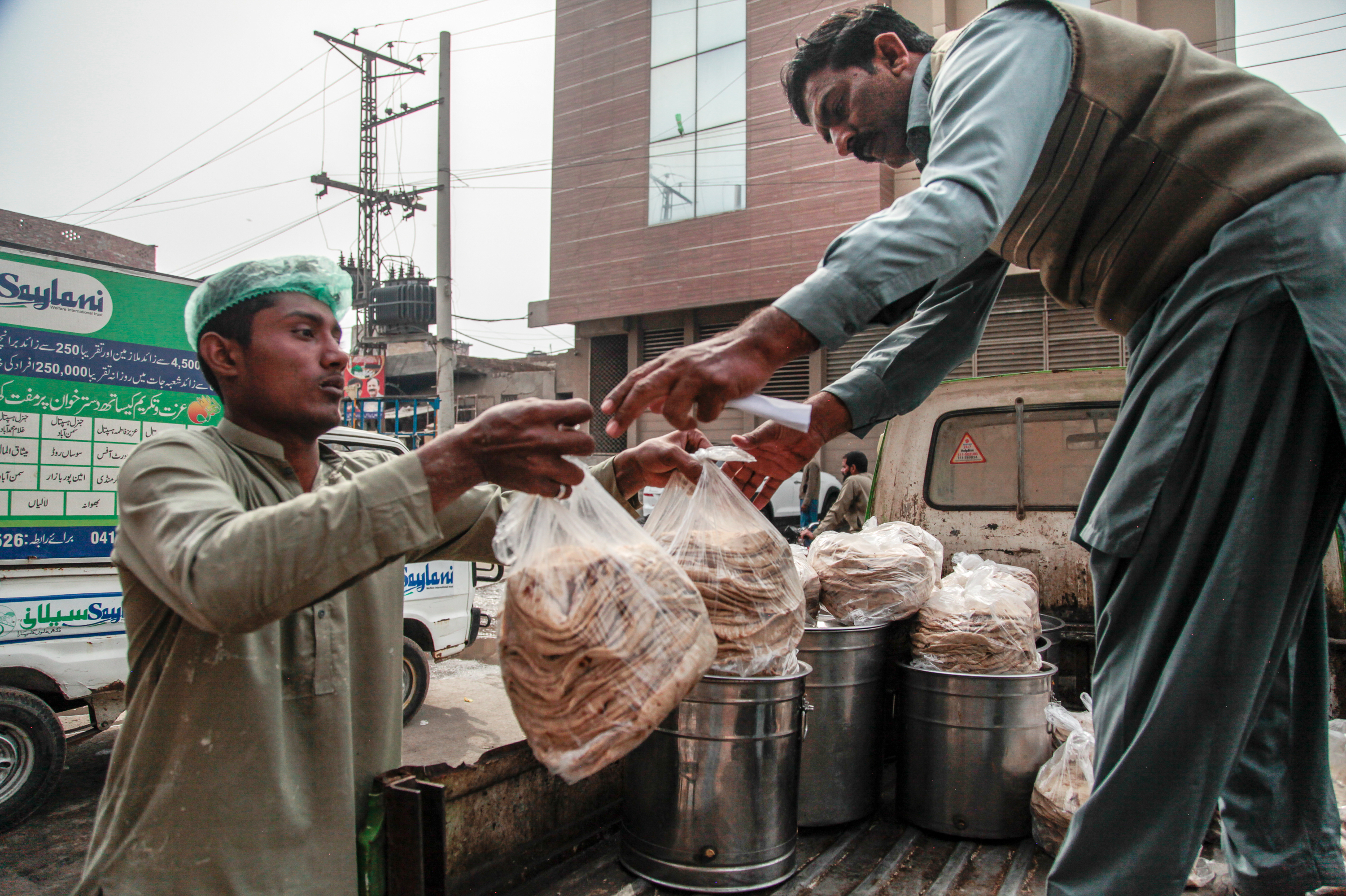 Workers at the Pakistani charity Saylani load freshly-cooked flat bread, or naan, into an open-backed jeep. The food will be distributed to 40 free cafeterias run by the charity in the city of Faisalabad. It's a place considered prosperous by Pakistani standards, but the charity says workers are going hungry because soaring inflation means they can't afford food.