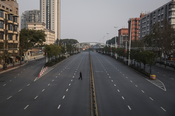 A man crosses an empty highway road on February 3, 2020 in Wuhan, Hubei province, China.