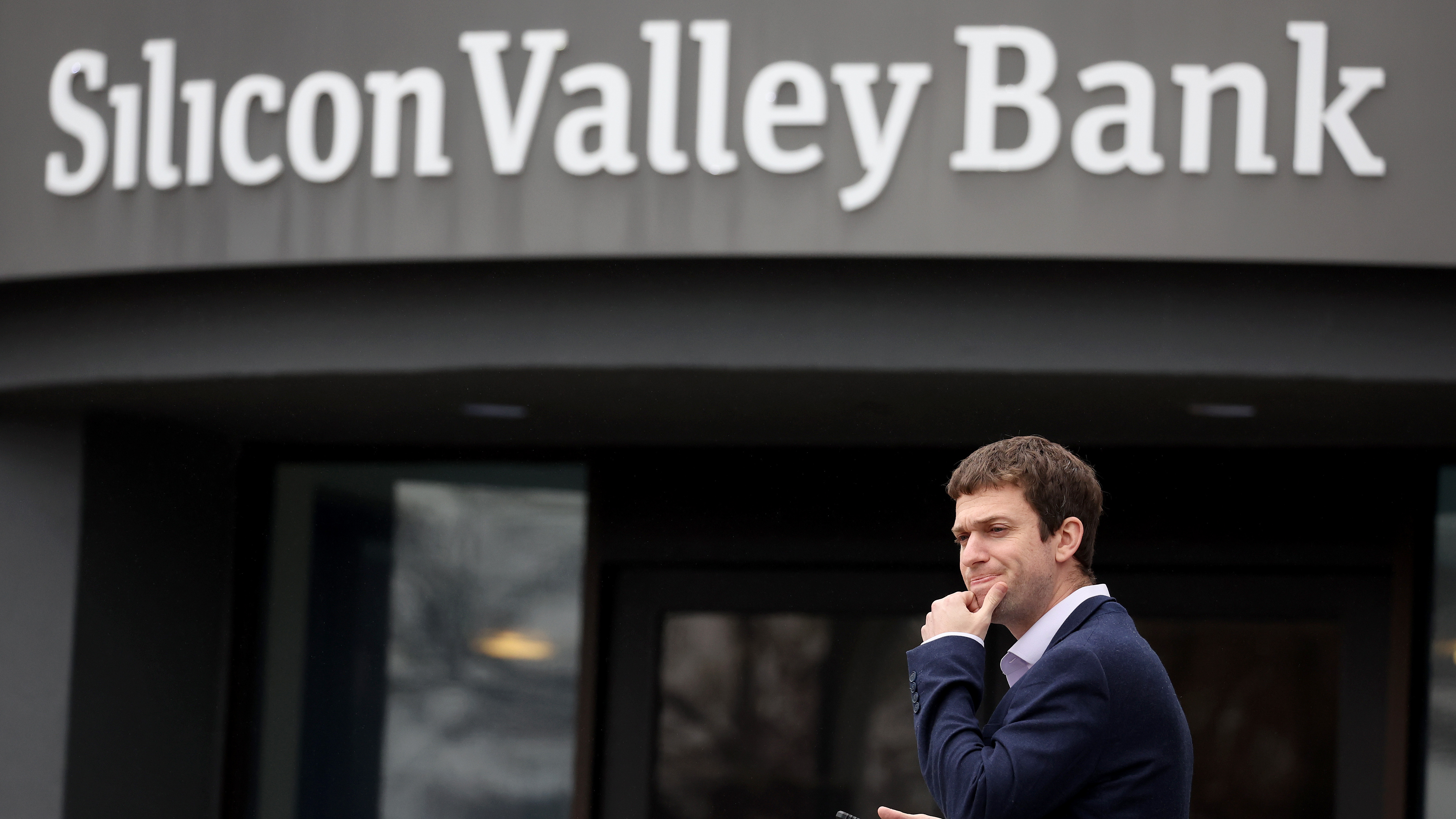 A customer stands outside of the shuttered Silicon Valley Bank headquarters in Santa Clara, Calif., on March 10, 2023. The lender was taken over federal regulators on Friday, marking one of the largest bank failures since the 2008 Global Financial Crisis.