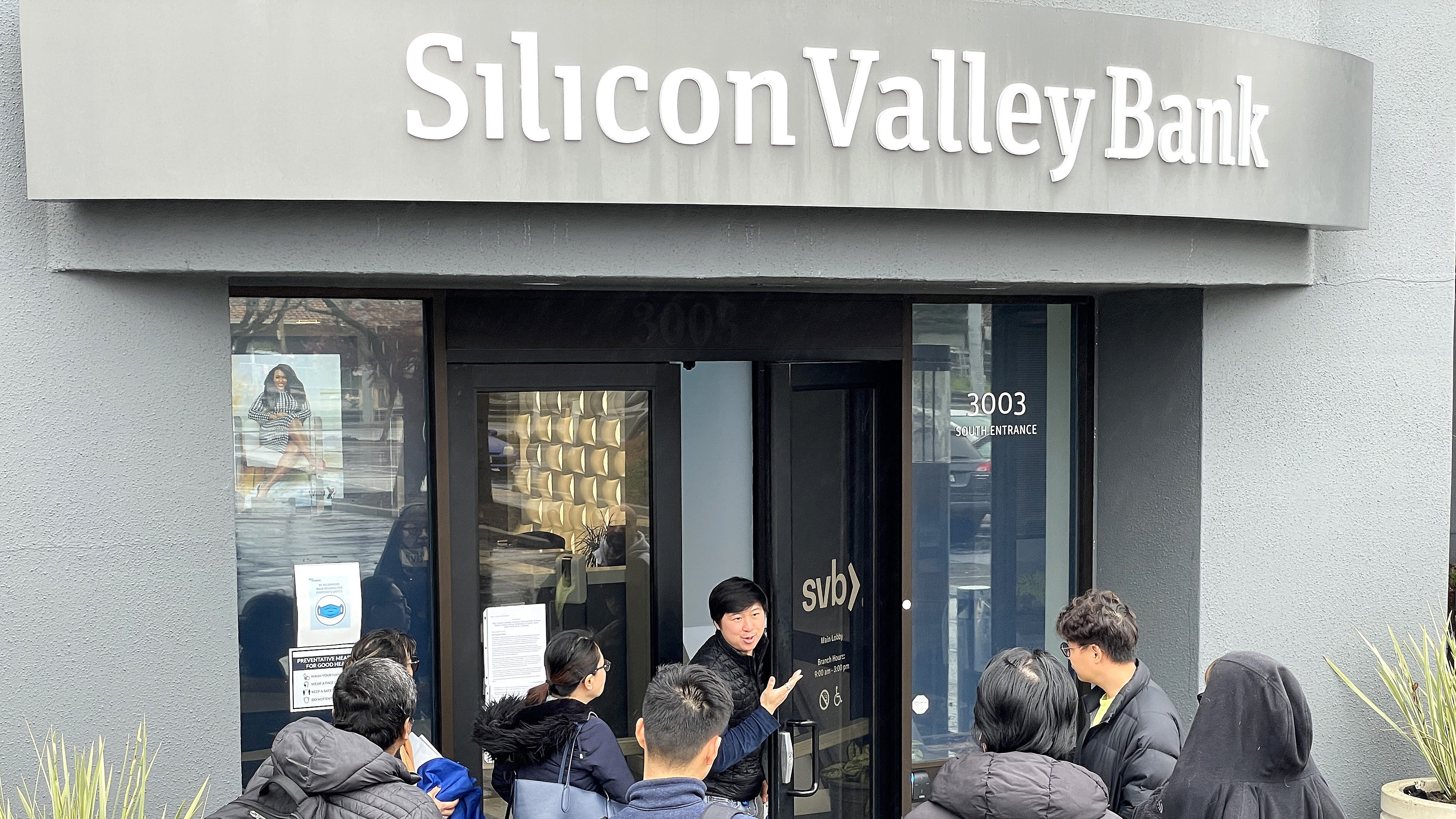 A worker tells people that the Silicon Valley Bank (SVB) headquarters in Santa Clara, Calif., is closed on March 10, 2023. Federal regulators took extraordinary measures on Sunday to backstop all deposits at SVB after the lender