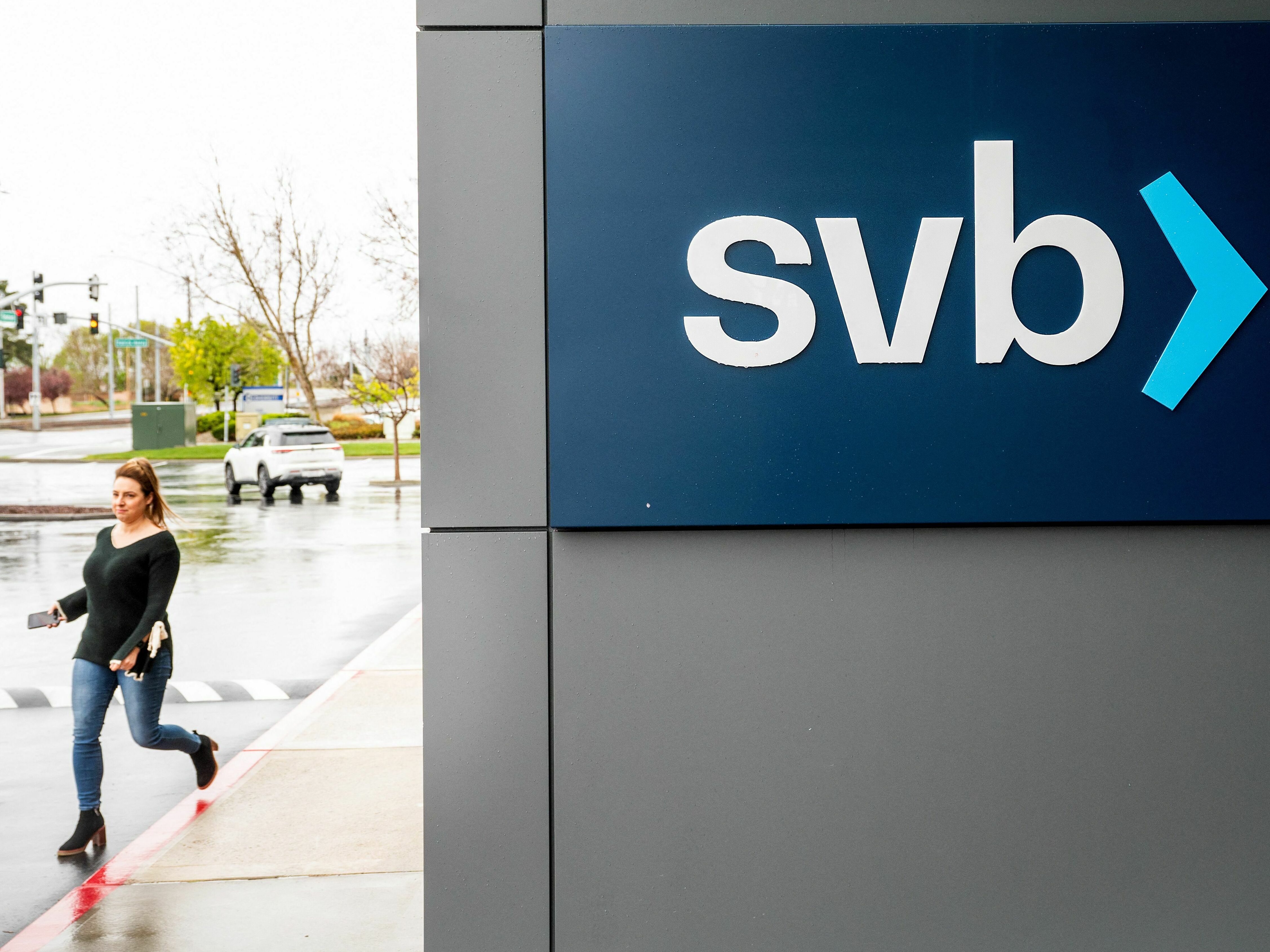 A property manager representative passes a sign at Silicon Valley Banks headquarters in Santa Clara, California on March 10, 2023. (AFP via Getty Images)