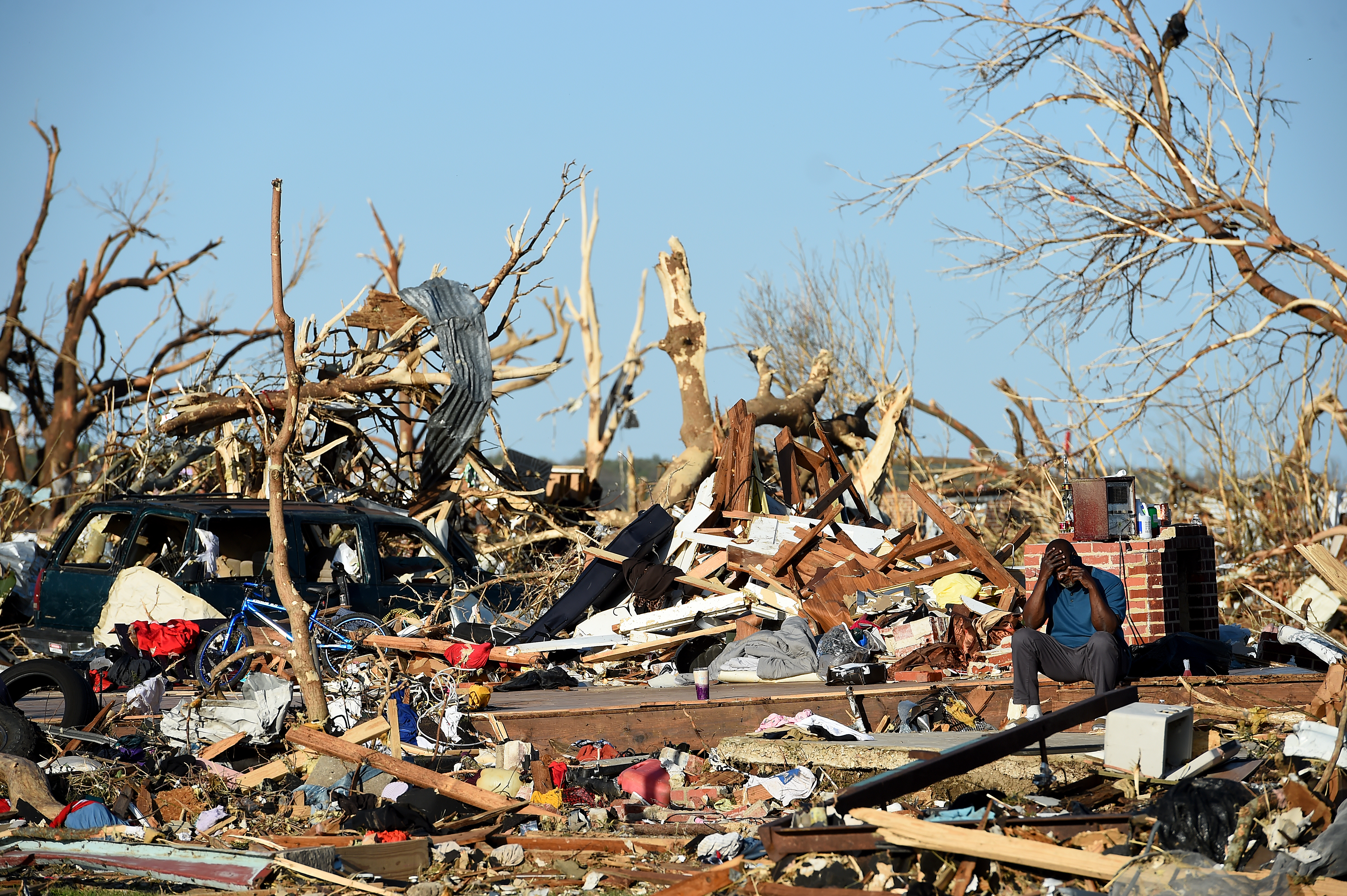 A man sits among the wreckage caused by a series of powerful storms and at least one tornado on March 25, 2023 in Rolling Fork, Mississippi. (Getty Images)