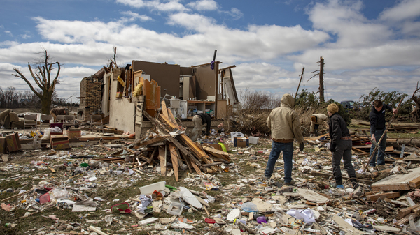 Family and neighbors look through debris on Ed Whestine
