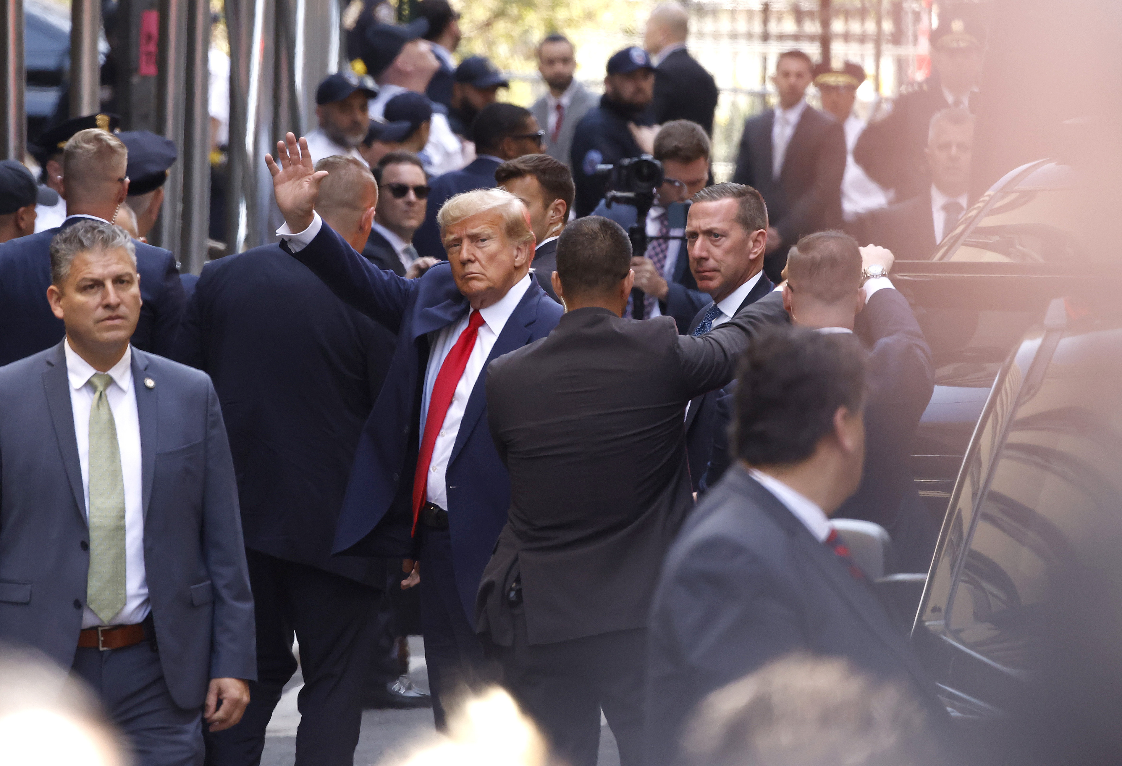 Former President Donald Trump waves as he arrives at the Manhattan Criminal Court on April 04, 2023 in New York, New York.