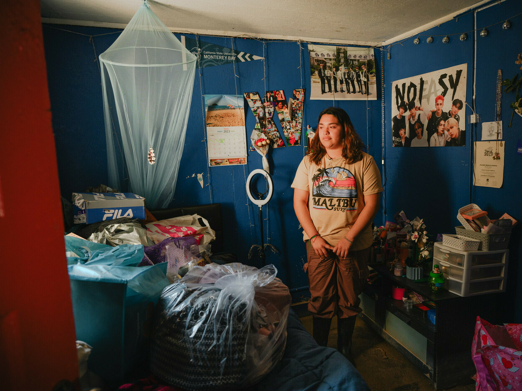 Climate activist and Pajaro Valley High School senior Denia Escutia, 18, looks around a mud-coated bedroom in Pajaro, California on March 24, 2023. Days earlier, residents began returning to their homes after a levee breach flooded the area several weeks earlier. (Kori Suzuki / KQED News)