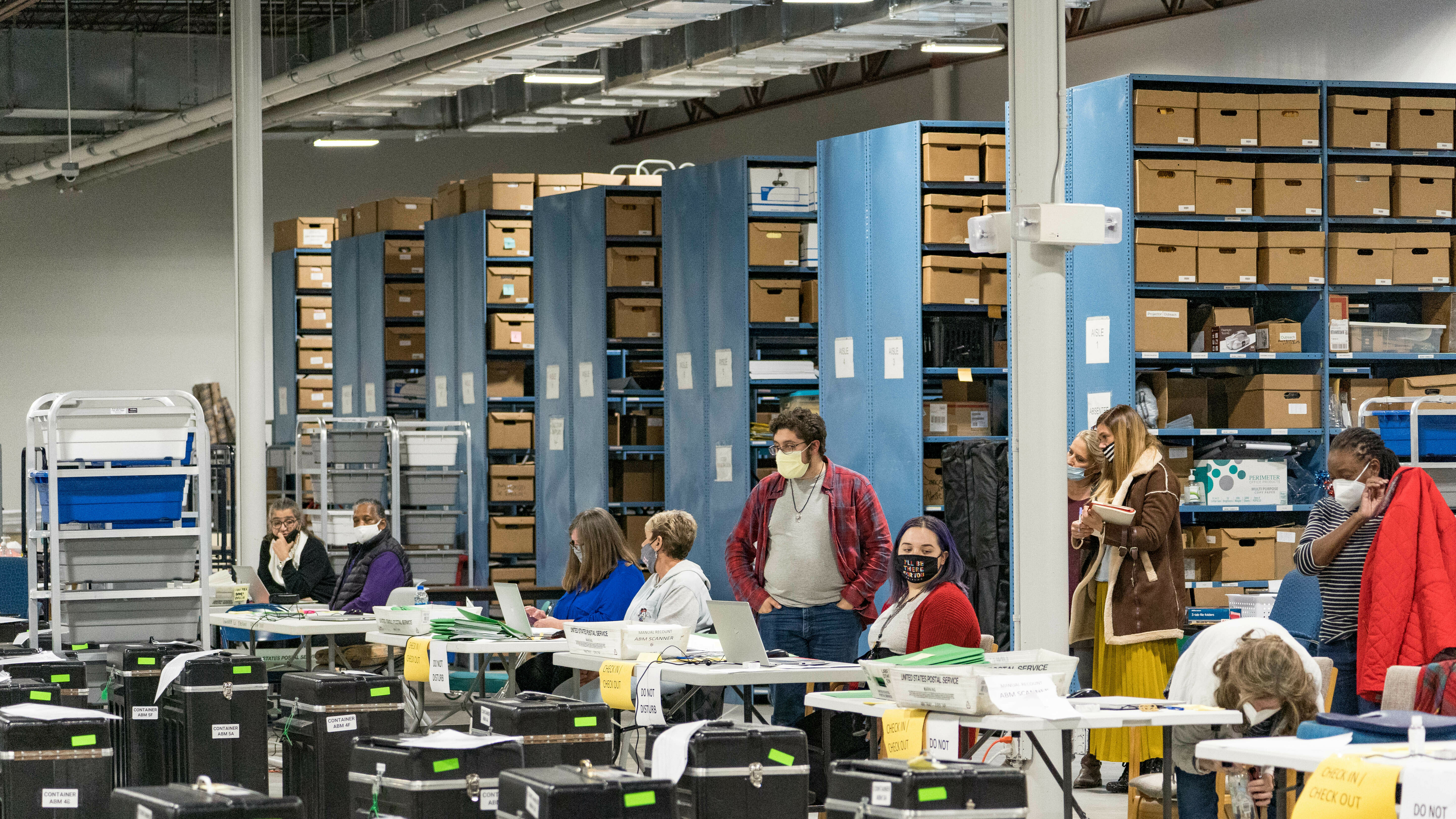 Gwinnett County election workers prepare to handle ballots as part of the recount for the 2020 presidential election on Nov. 16, 2020, in Lawrenceville, Georgia. Nearly two and a half years after the election, voting machine companies, election workers and even a local postmaster have filed defamation cases tied to conspiracy theories that have spread about the election.