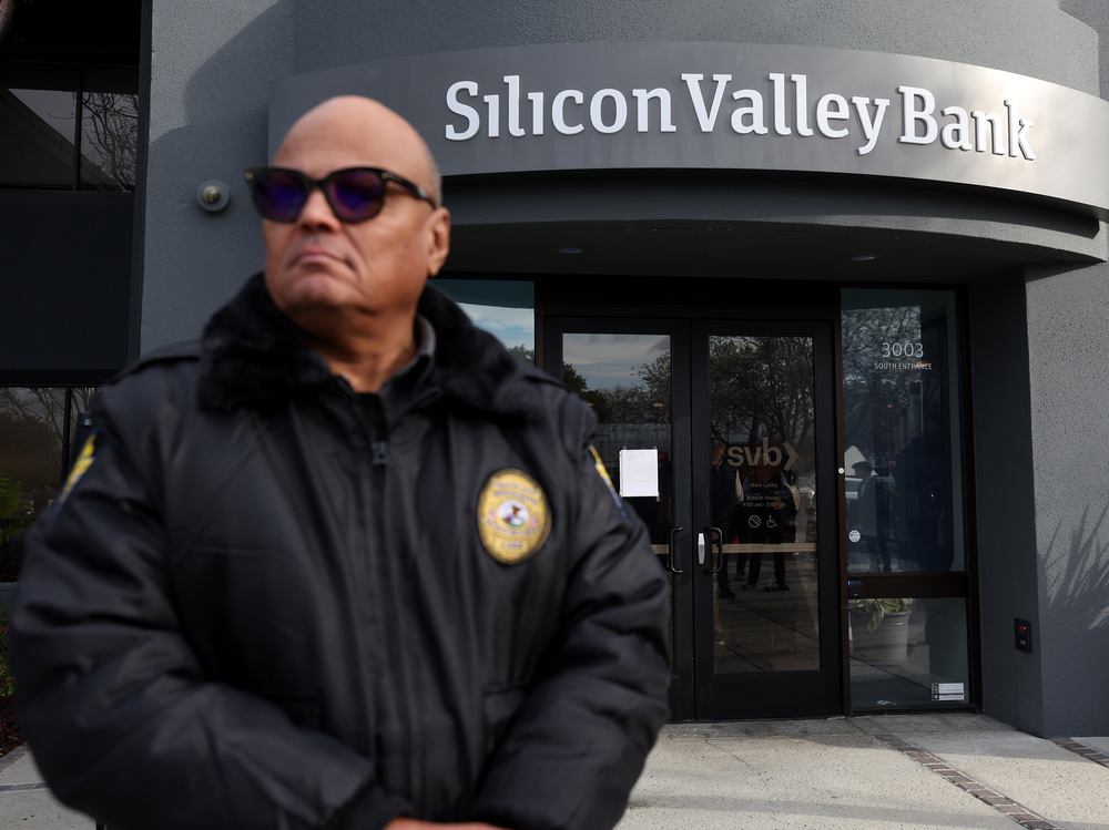 A security guard at Silicon Valley Bank monitors a line of people outside the office in Santa Clara, Calif., on March 13, 2023. The Fed admitted it was partly to blame for the collapse of the lender in a scathing report on Friday. (Getty Images)