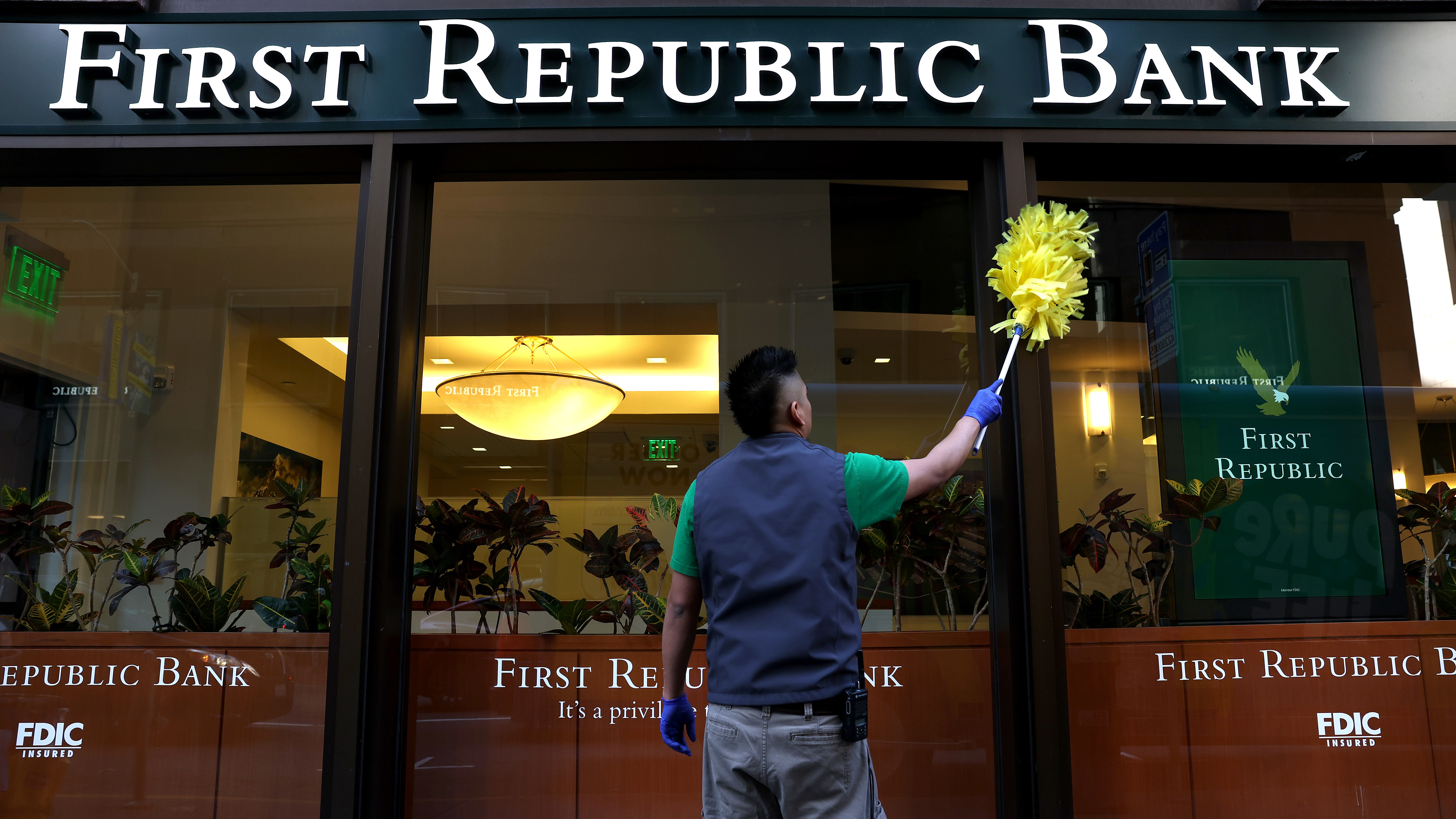 A worker cleans the outside of a First Republic bank in San Francisco.