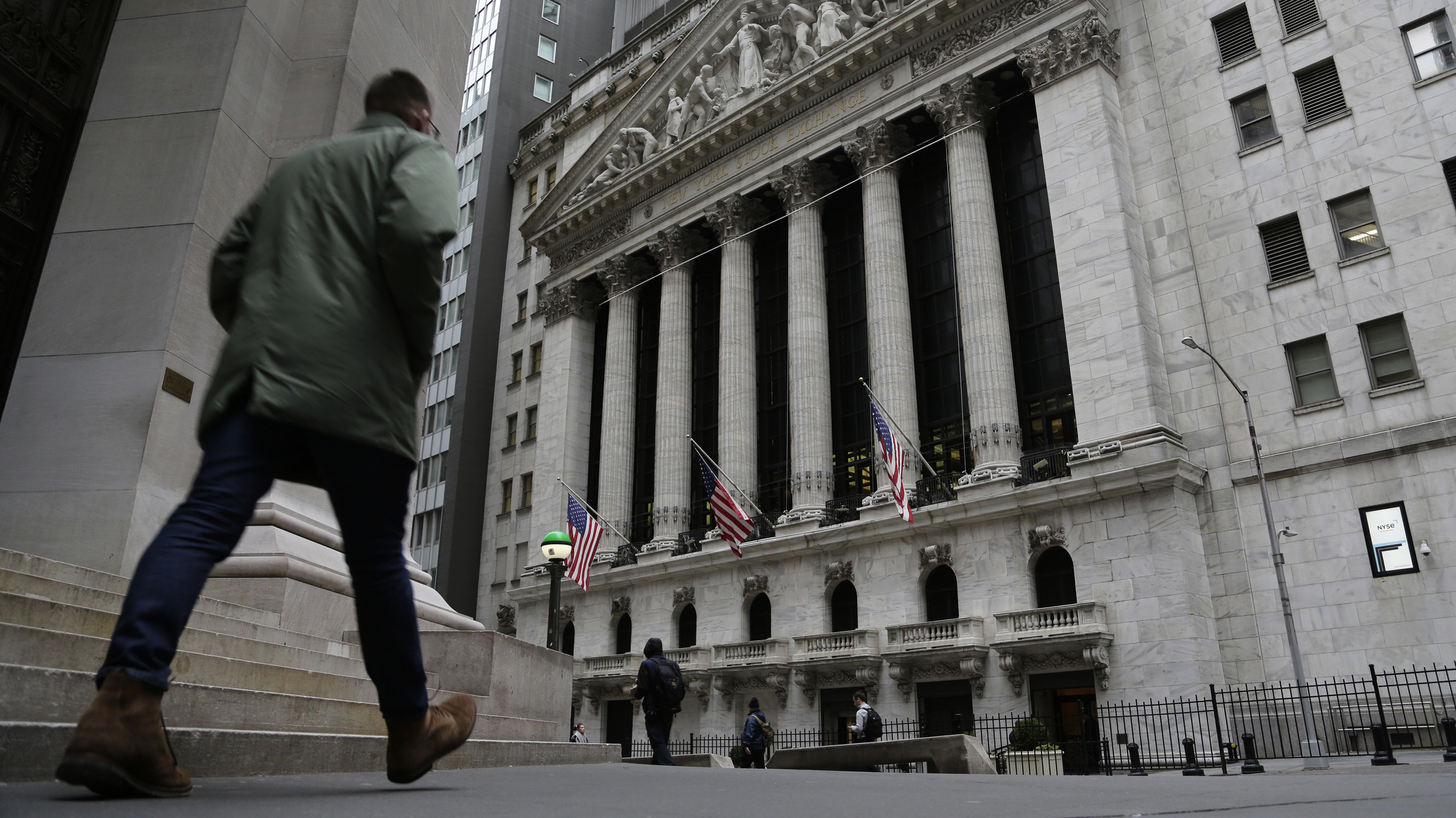 People pass the front of the New York Stock Exchange in New York, on March 22. Brinkmanship in Washington over raising the U.S. debt ceiling has begun to raise worries in parts of the financial markets.