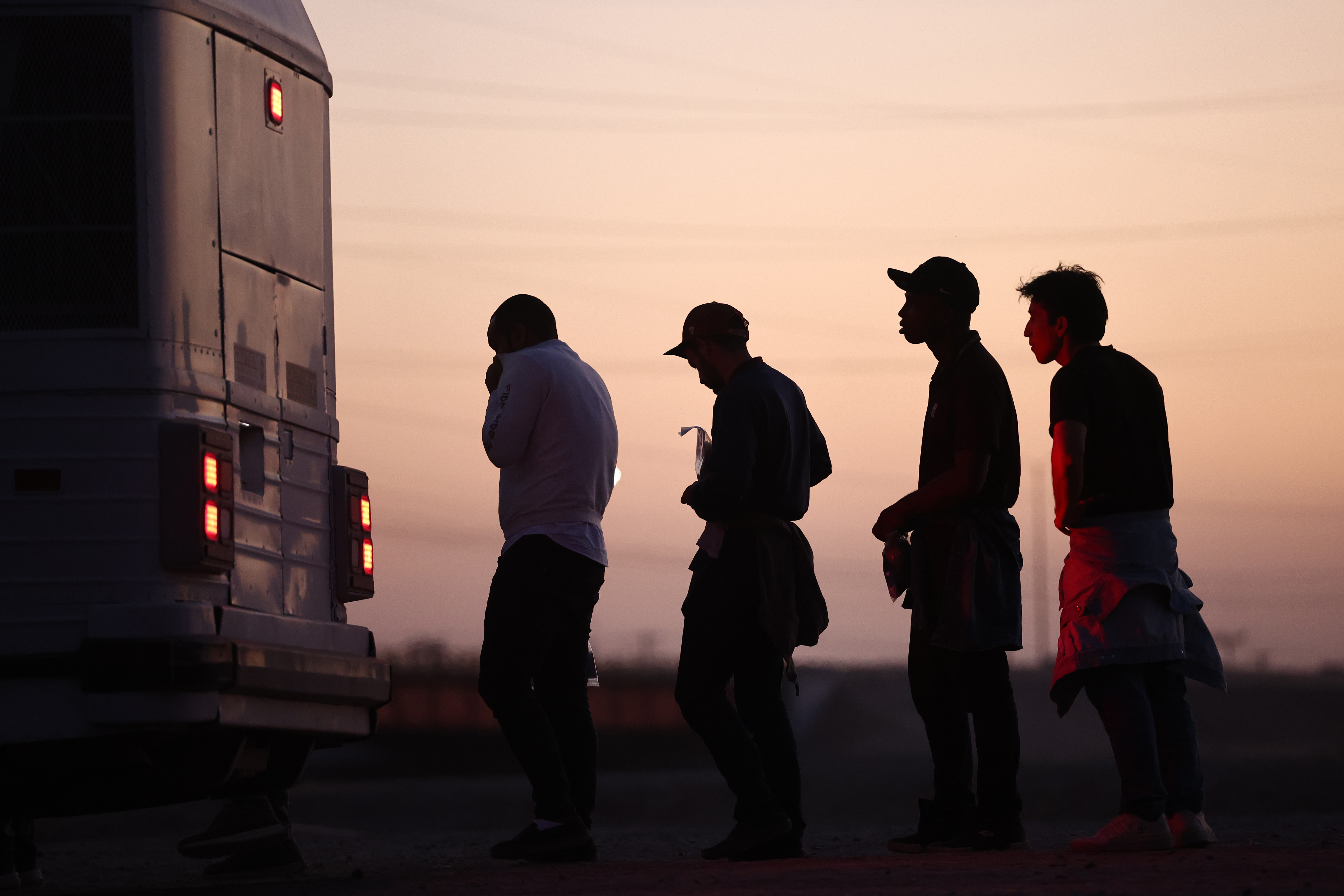 Immigrants seeking asylum wait to board a bus to a U.S. Border Patrol processing center, after crossing into Arizona from Mexico, on Thursday in Yuma, Ariz. (Getty Images)