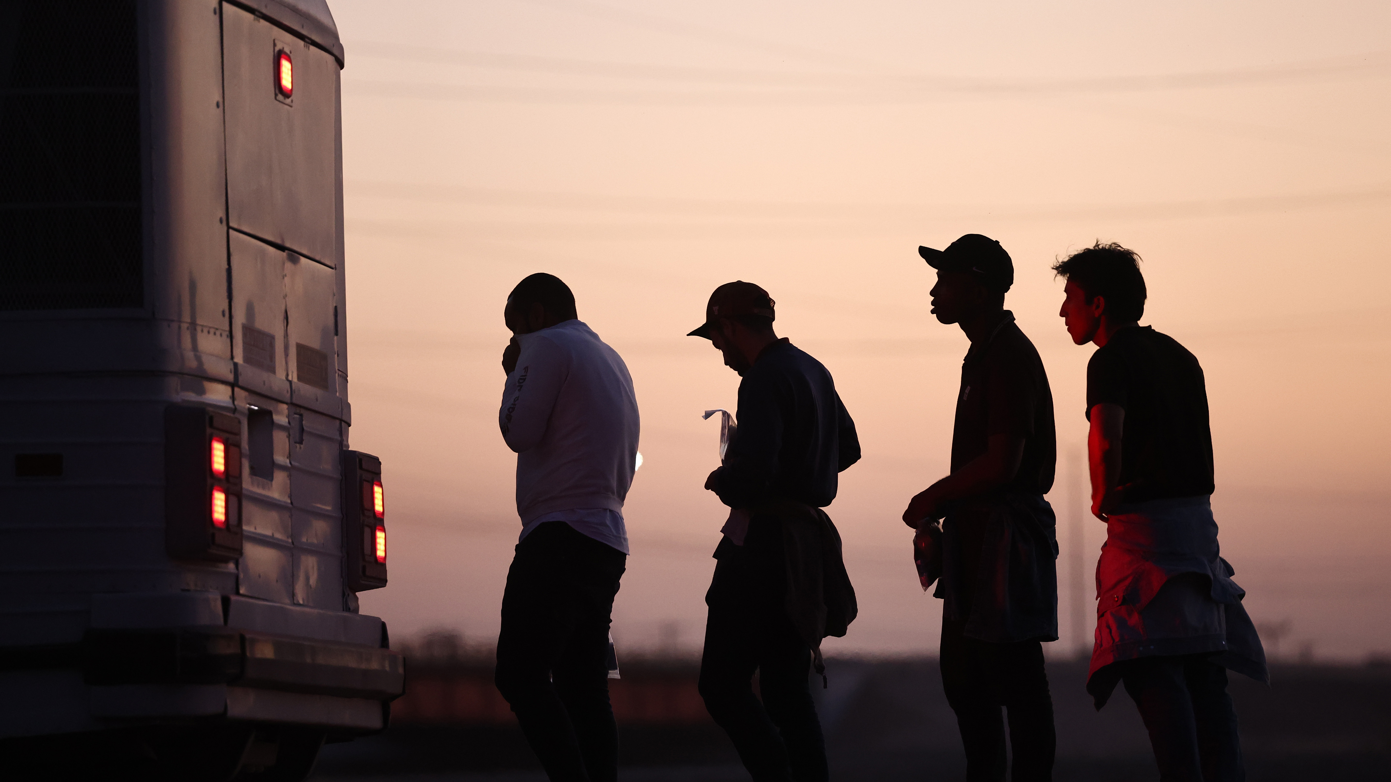 Immigrants seeking asylum wait to board a bus to a U.S. Border Patrol processing center, after crossing into Arizona from Mexico, on Thursday in Yuma, Ariz.
