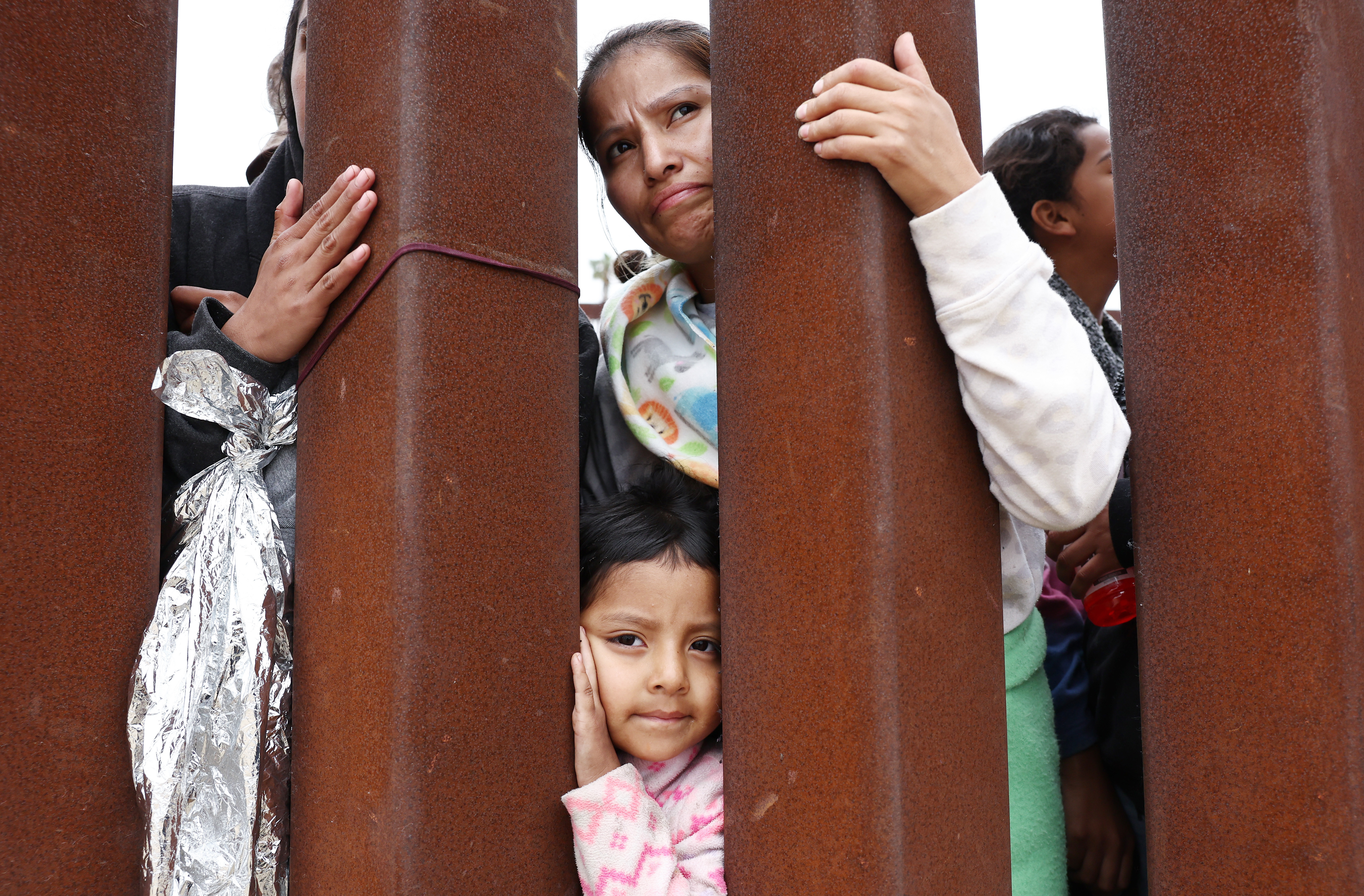 A mother and daughter await volunteer assistance while stuck in a makeshift camp at the U.S.-Mexico border. (Getty Images)