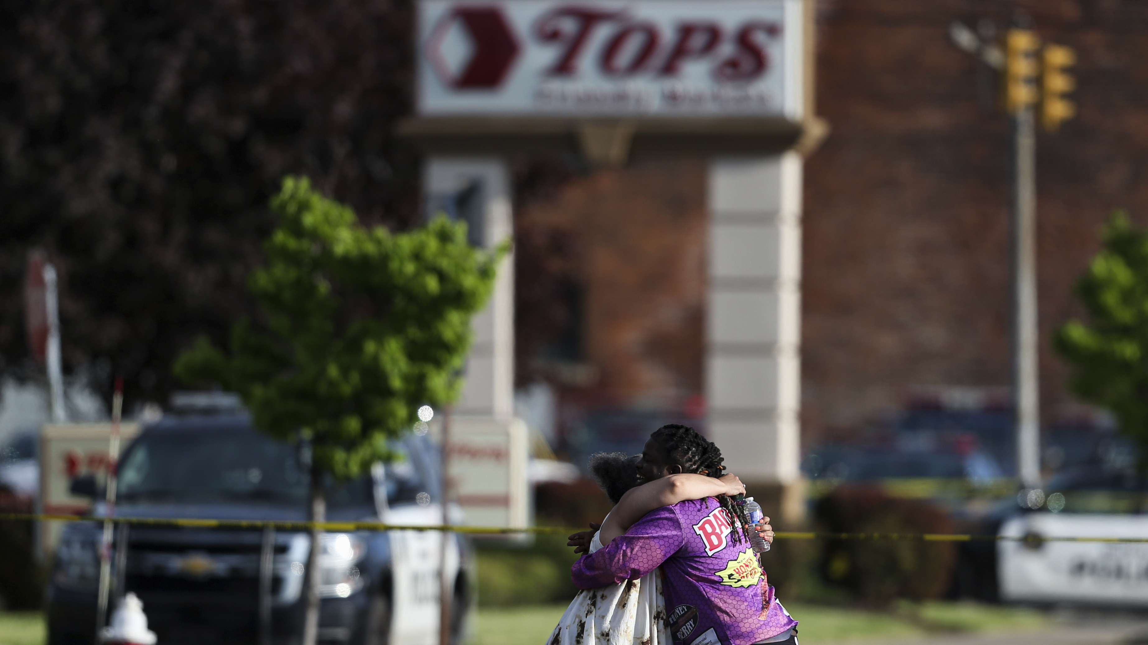 People hug outside the scene after a shooting at a supermarket on May 14, 2022, in Buffalo, N.Y.
