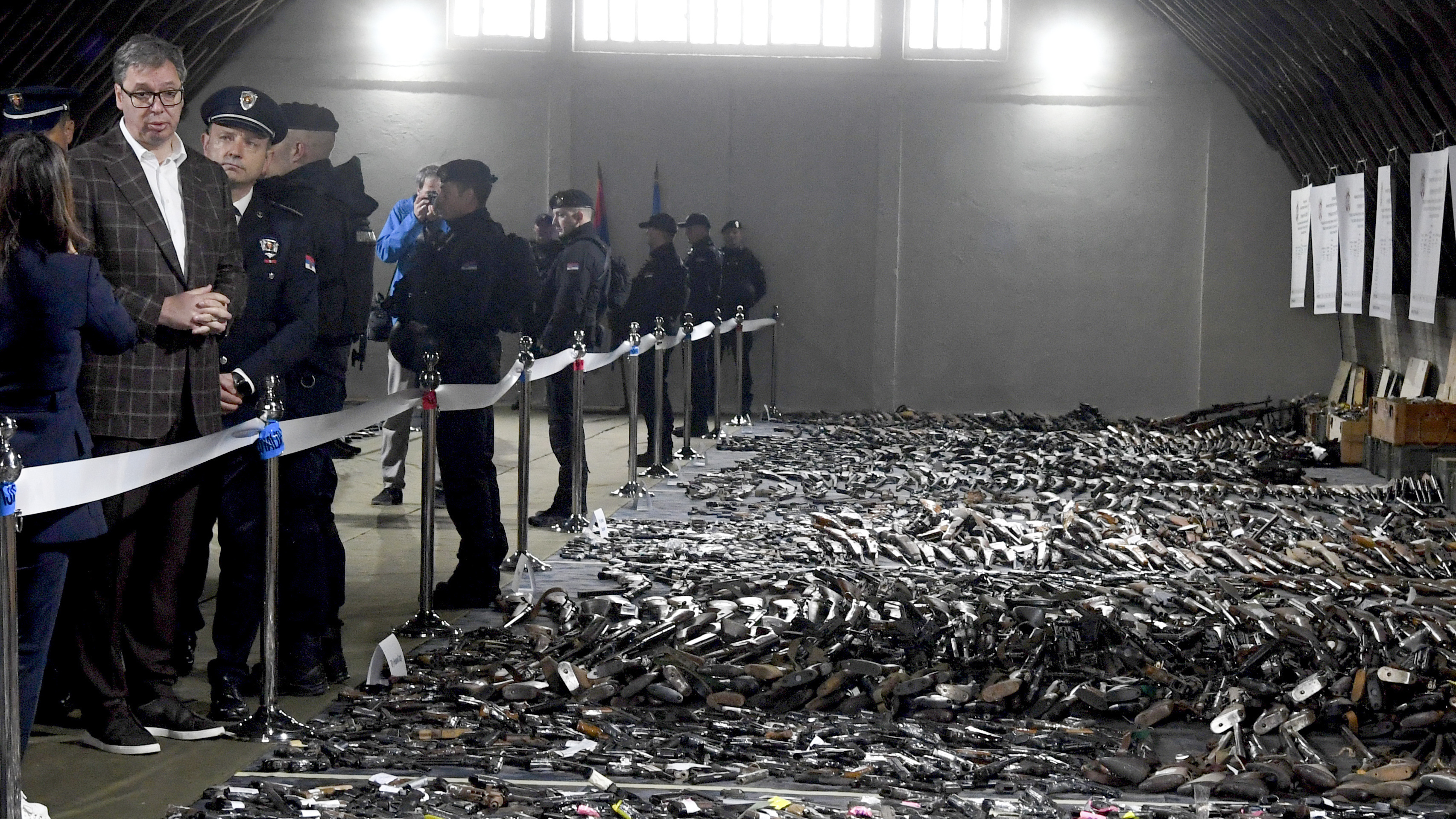 In this photo provided by the Serbian Presidential Press Service, Serbian President Aleksandar Vucic, left, inspects weapons collected as part of an amnesty near the city of Smederevo, Serbia, Sunday, May 14, 2023.