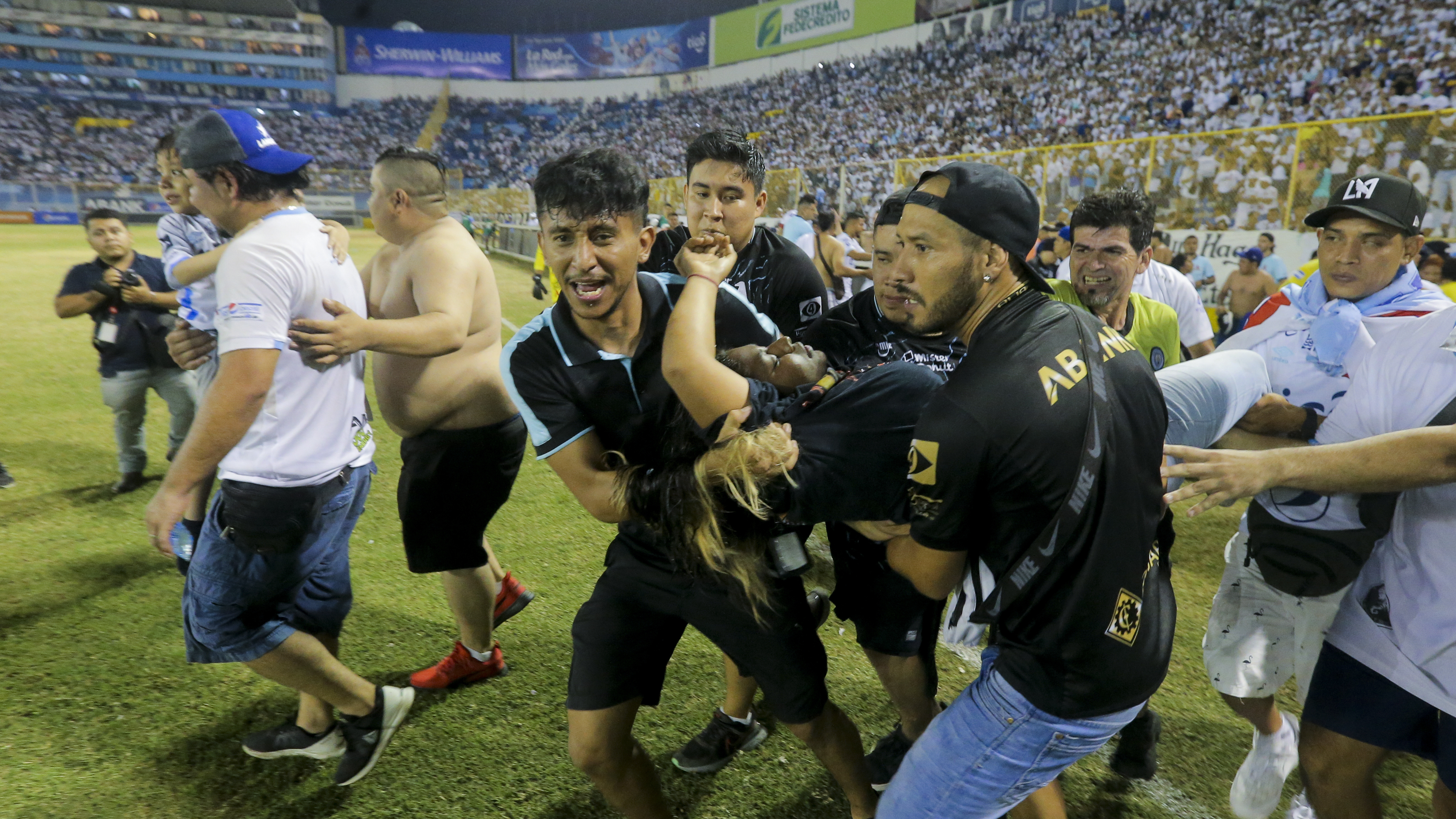 An injured fan in carried to the field of Cuscatlan stadium in San Salvador, El Salvador, Saturday, May 20, 2023. At least nine people were killed and dozens more injured when stampeding fans pushed through one of the access gates at a quarterfinal Salvadoran league soccer match between Alianza and FAS.
