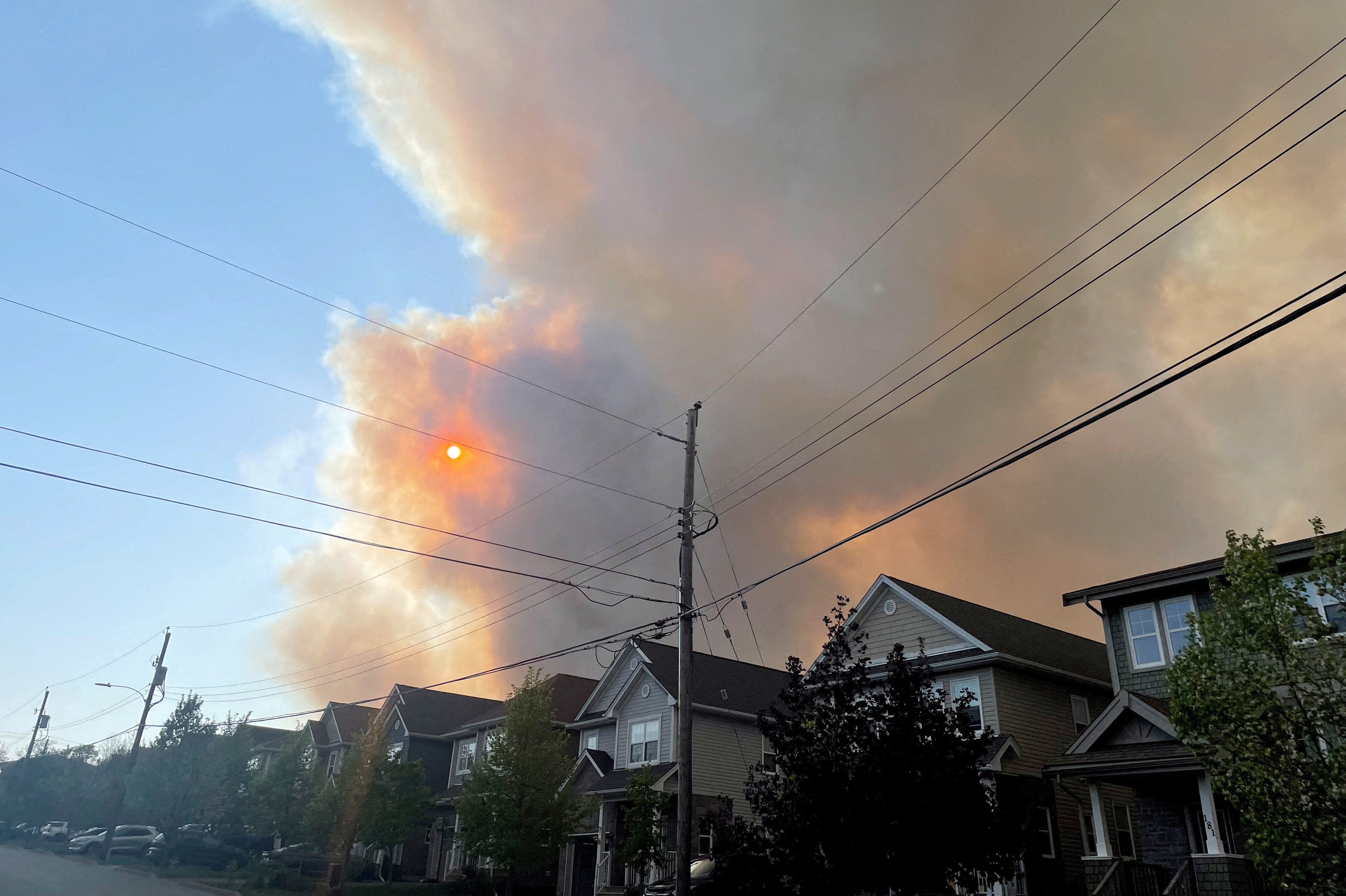 Smoke from the Tantallon wildfire rises over houses in nearby Bedford, Nova Scotia, Canada, on Sunday. (Reuters)