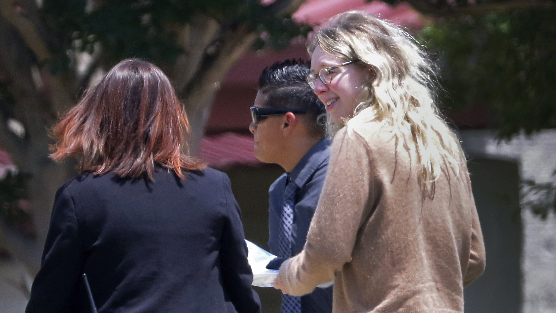 Disgraced Theranos CEO Elizabeth Holmes is escorted by prison officials into a federal women