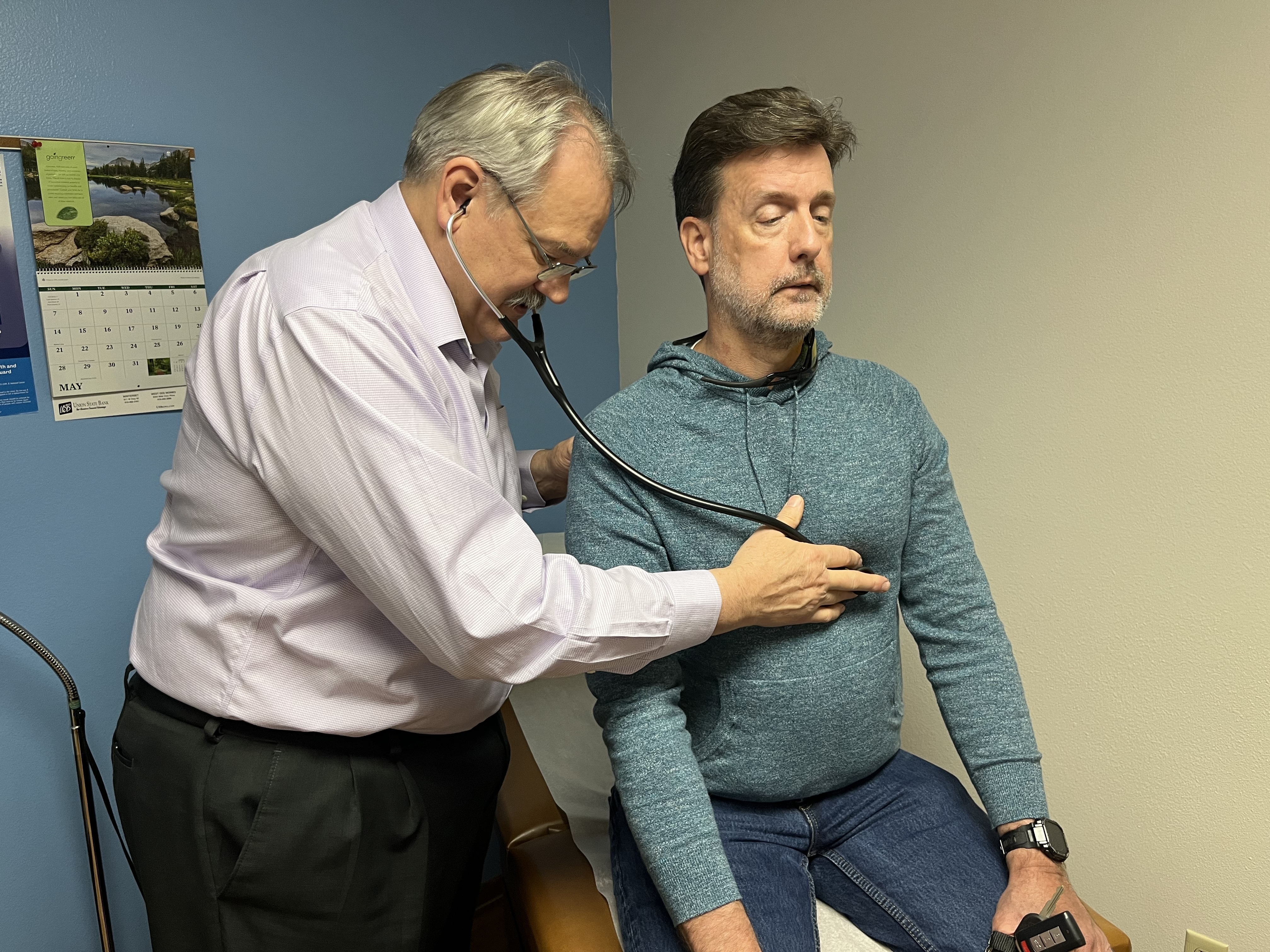 Osteopathic physician Kevin de Regnier of Winterset, Iowa, checks Chris Bourne, who came in for an adjustment of his anxiety medication on May 9, 2023. (Tony Leys/KFF Health News)