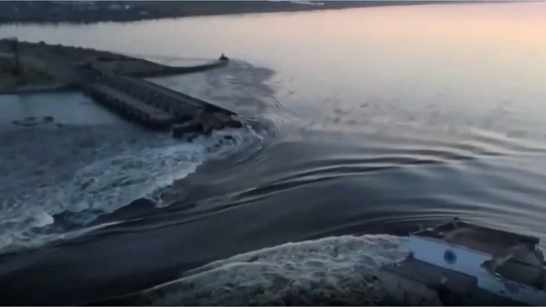 In a photo taken from video released by the Ukrainian Presidential Office, water surges through a break in the Kakhovka dam in southern Ukraine. Ukraine and Russia are both accusing each other of blowing up the dam, which also destroyed an attached hydroelectric power station.