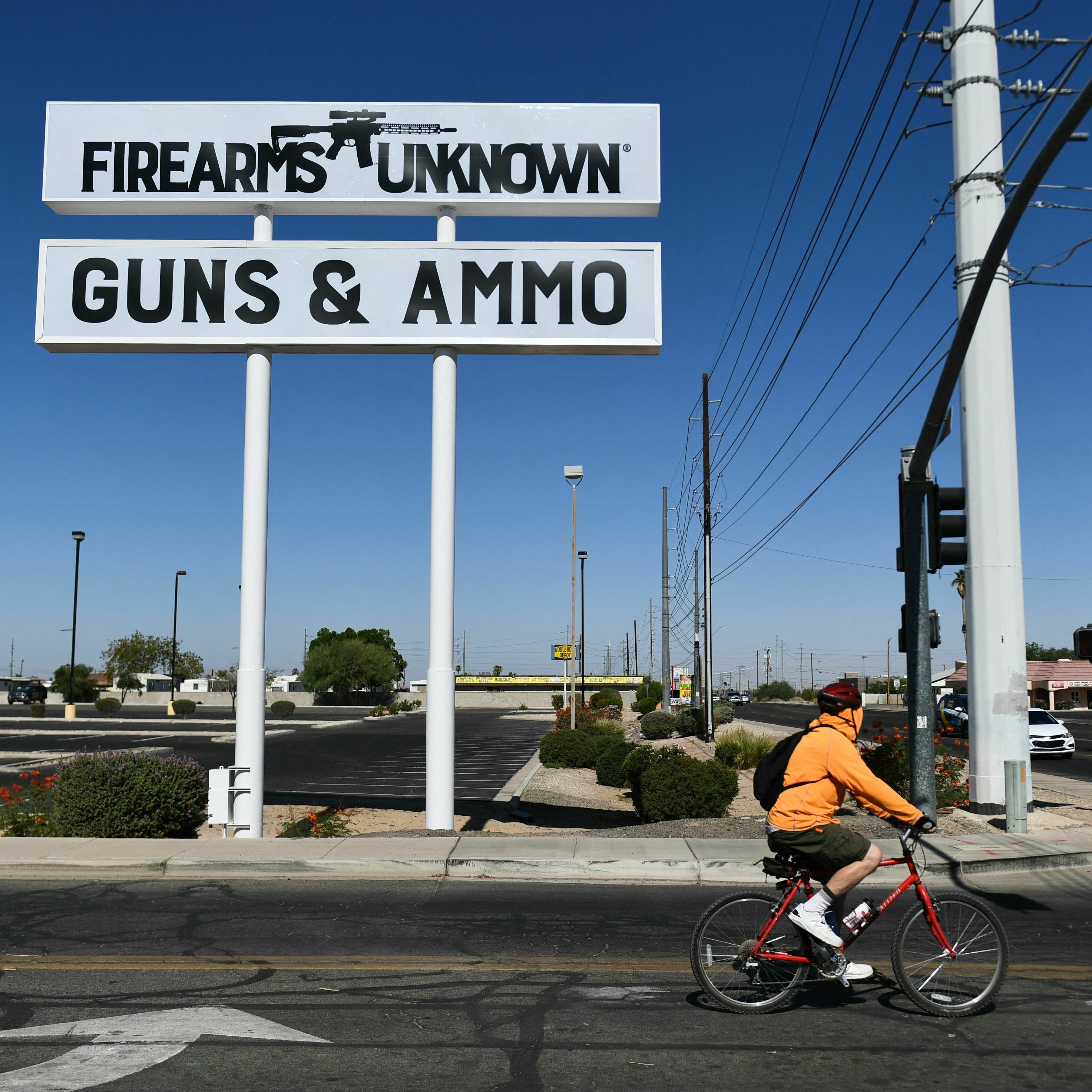The silhouette AR-15-style rifle is displayed on signage for the Firearms Unknown Guns & Ammo gun store in Yuma, Ariz., last week. (AFP via Getty Images)