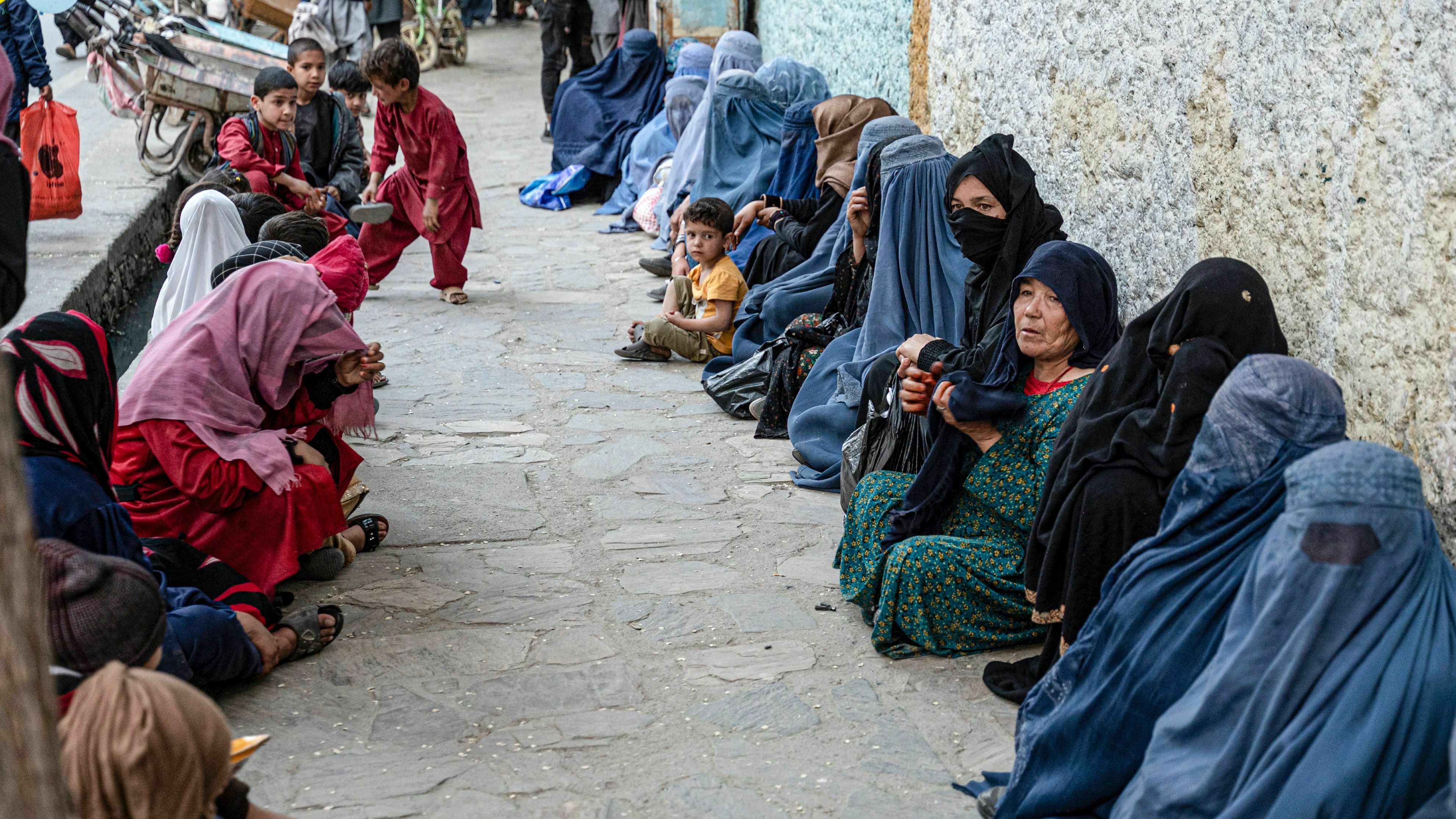 Afghan women wait for a free bread. Charities allege that the Taliban interferes with their distribution of aid by pressuring them to funnel money to the Taliban and its supporters.
