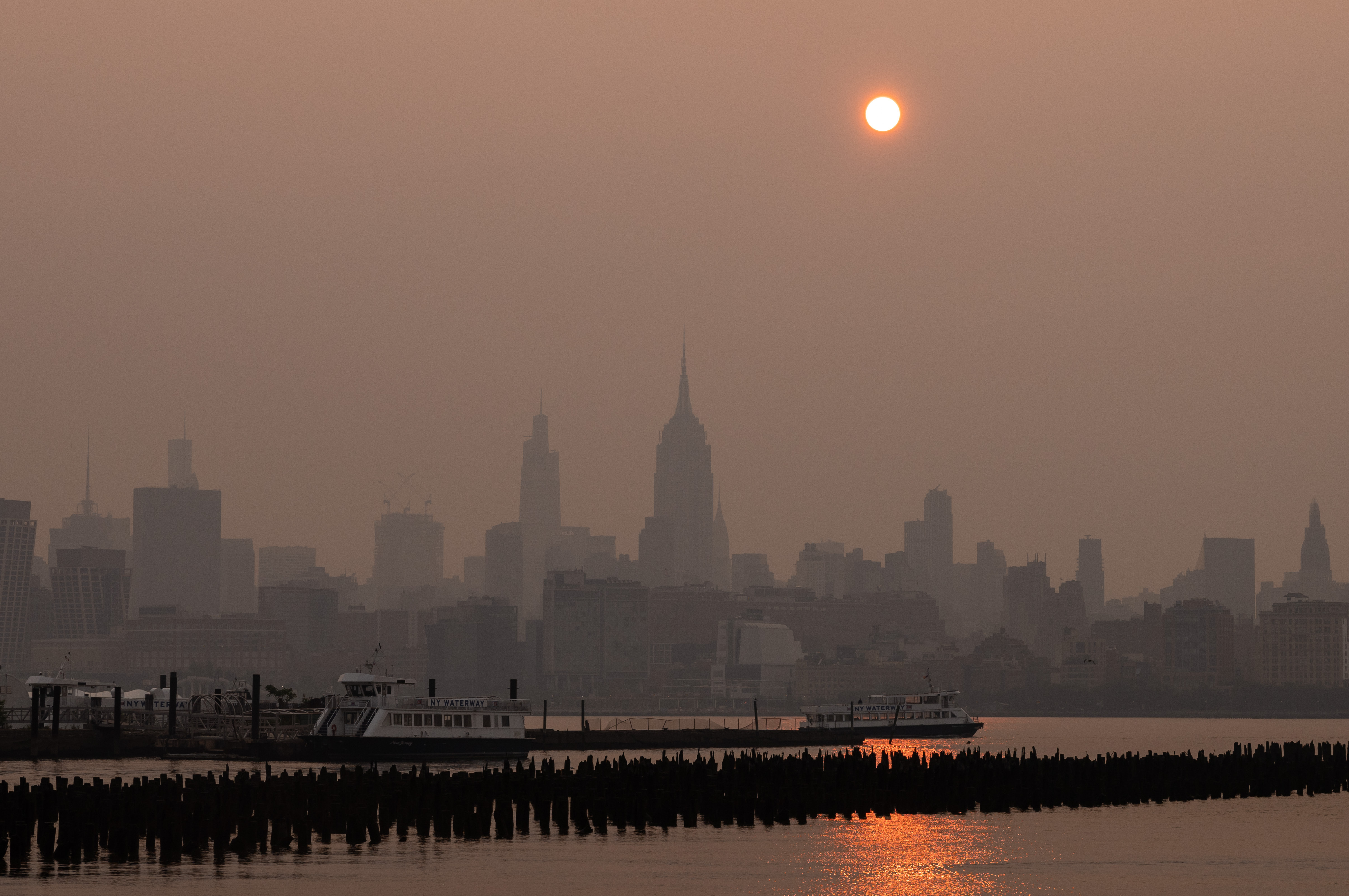 Buildings in the Manhattan skyline shrouded in smoke from Canada wildfires at sunrise in Jersey City, New Jersey, on Weds., June 7, 2023. New York was the most polluted major city in the world on Tuesday night, as smoke from Canadian wildfires blanketed the city in haze. (Bloomberg via Getty Images)