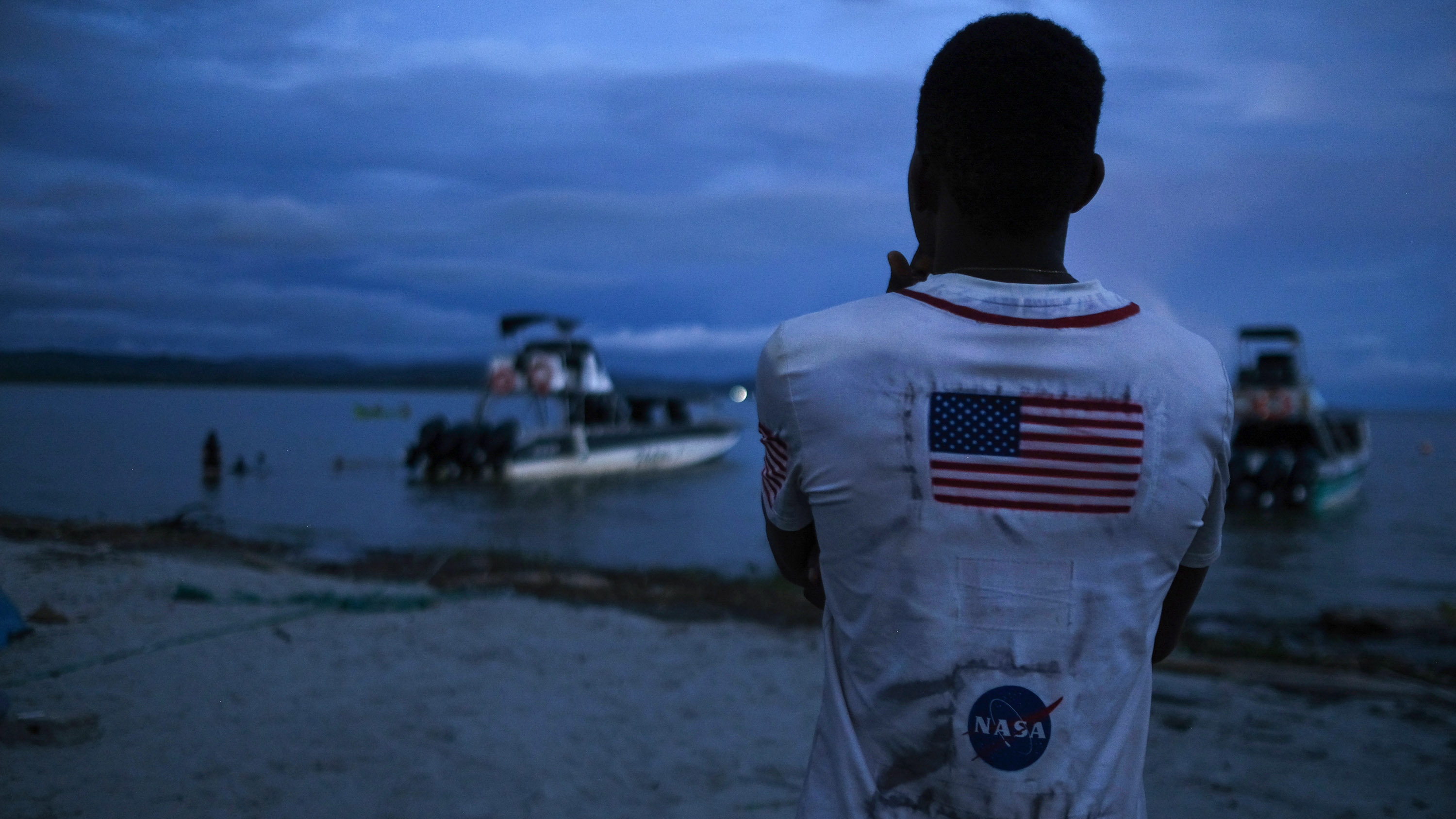 A Venezuelan migrant watches the boat he hopes to take across the Gulf of Urabá once he gets enough money together for the trip.
