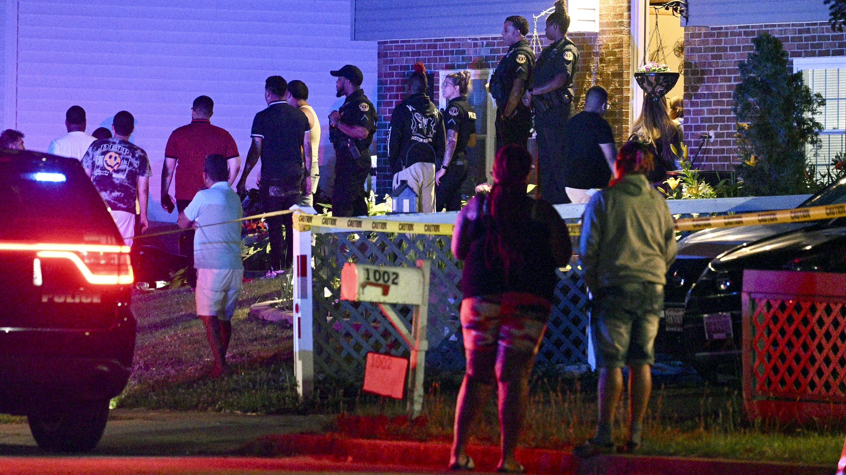 Police stand among a crowd outside a home where multiple people were shot in Annapolis, Md., on Sunday, June 11, 2023.