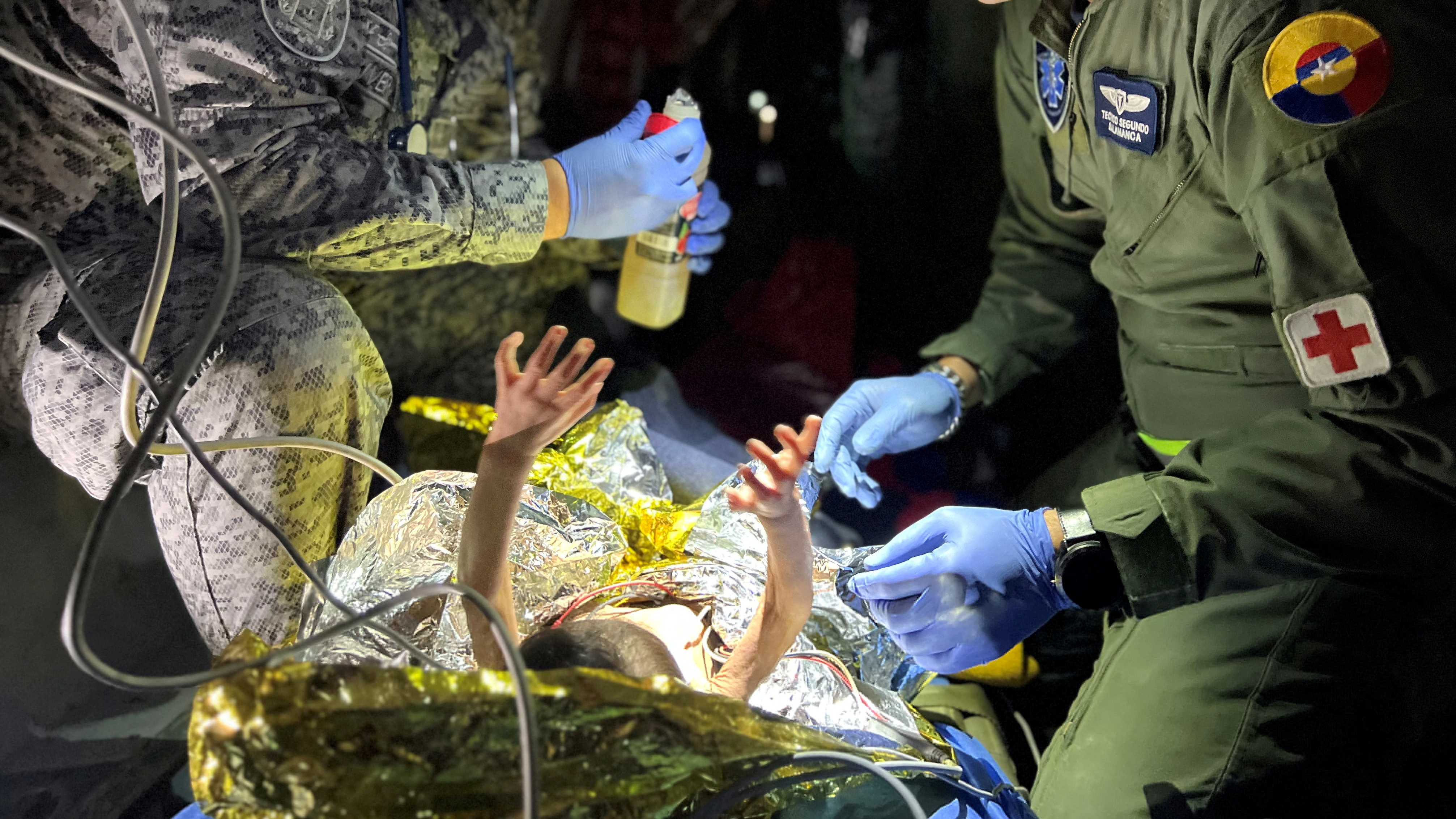 Soldiers of the Colombian Air Force give medical attention inside a plane to the children who survived a Cessna 206 plane crash in the thick jungle, while they are transferred to Bogotá by air in San José del Guaviare, Colombia, June 9.