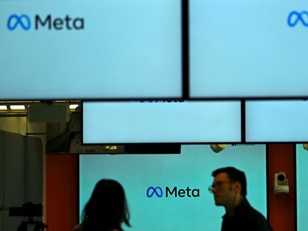 Visitors stand near screens displaying the Meta logo in Berlin on June 6. Under a U.S. judge's new ruling, much of the federal government is now barred from working with social media companies to address removing content that might contain &quot;protected free speech.&quot; (AFP via Getty Images)