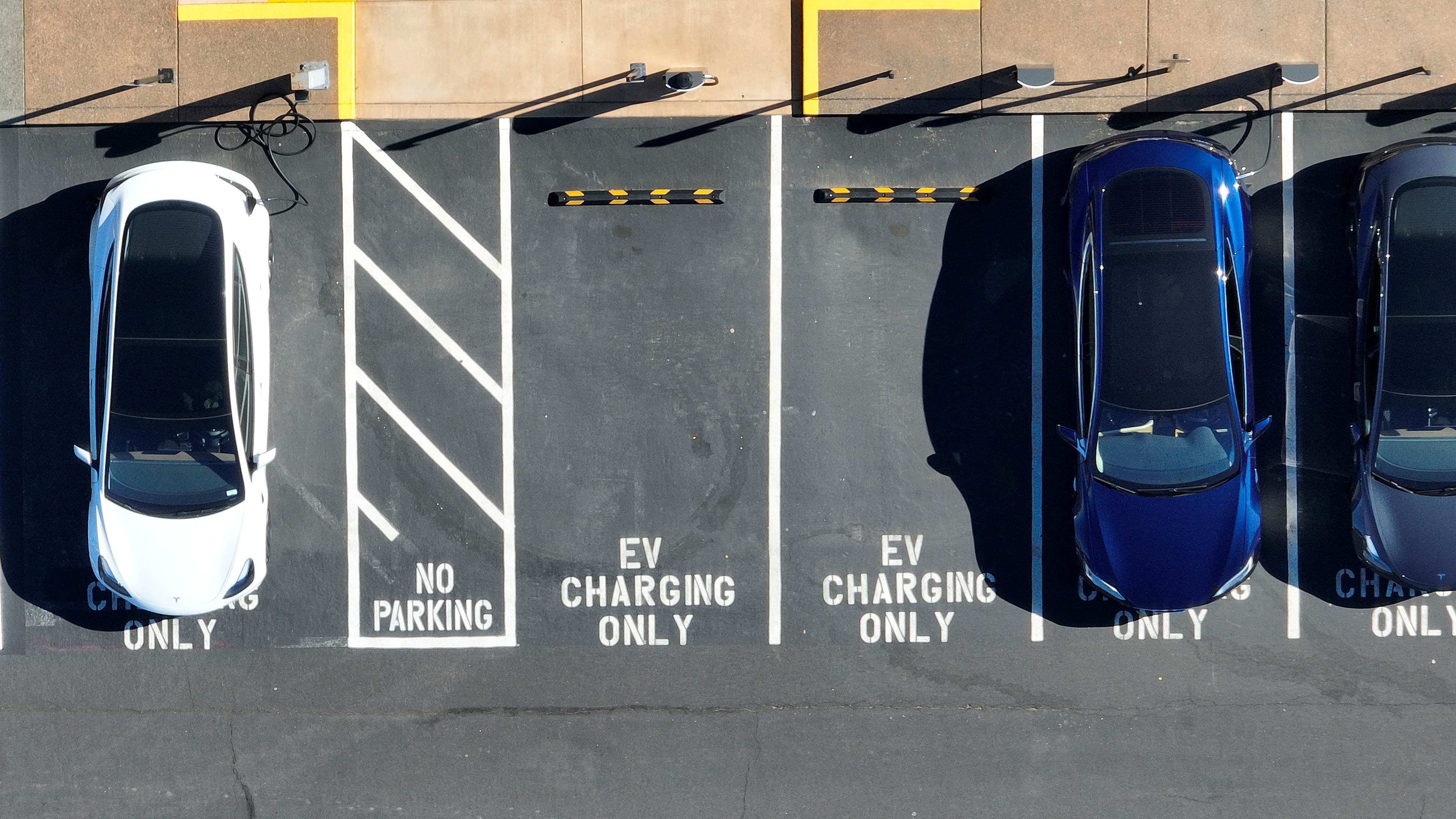 Tesla vehicles recharge in February in Corte Madera, Calif. The government wants to accelerate the transition to electric vehicle, but how fast the country can actually move is being hotly debated. (Getty Images)